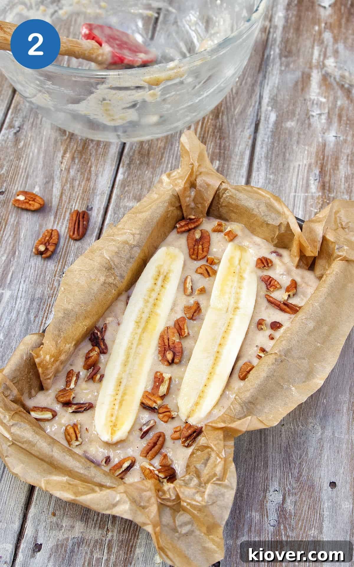 banana bread in baking tin ready to go in the oven. Baking tin is on wooden surface.