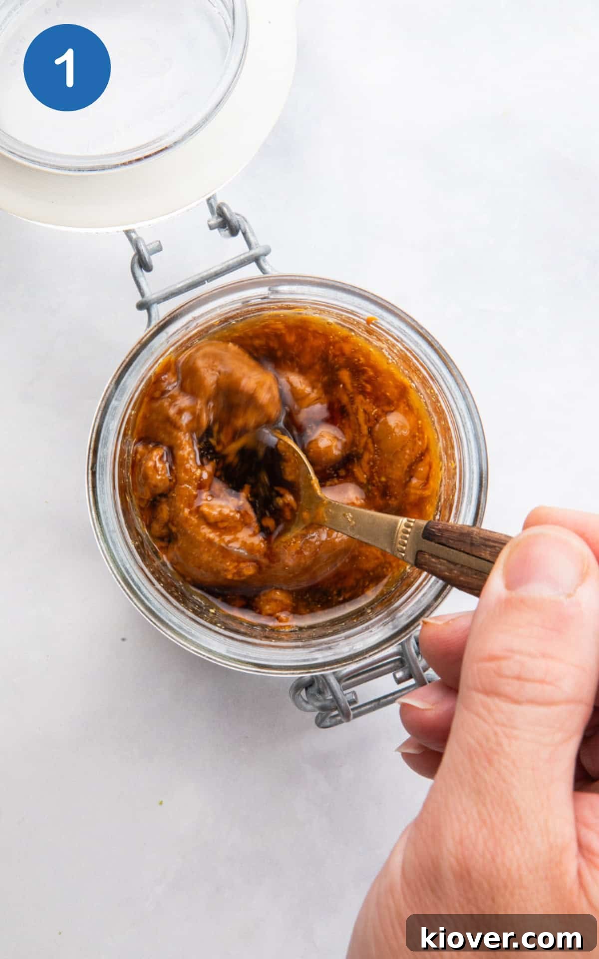 mixing the ingredients for peanut butter salad dressing in a glass jar.