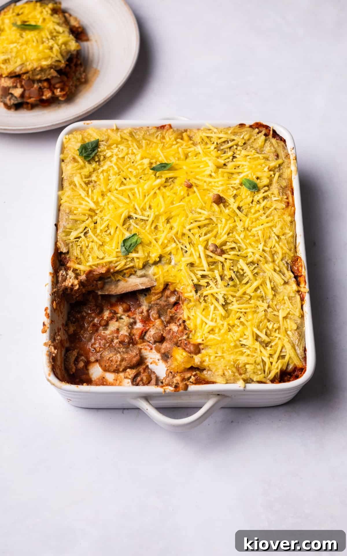 Vegan Greek Moussaka Recipe: Creamy Eggplant and Lentil Bake 11 vegan moussaka with grated vegan cheese on top.