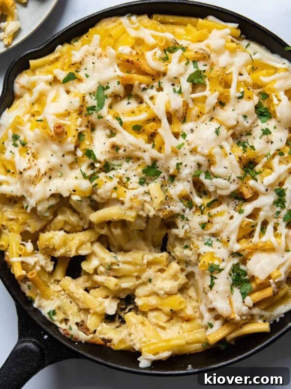 overhead shot of vegan Mac and cheese in a black skillet pan displayed on white background.