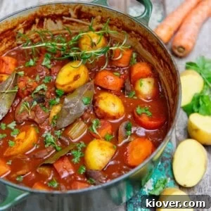 hearty potato stew cooked in a green pot, served on a wooden background.