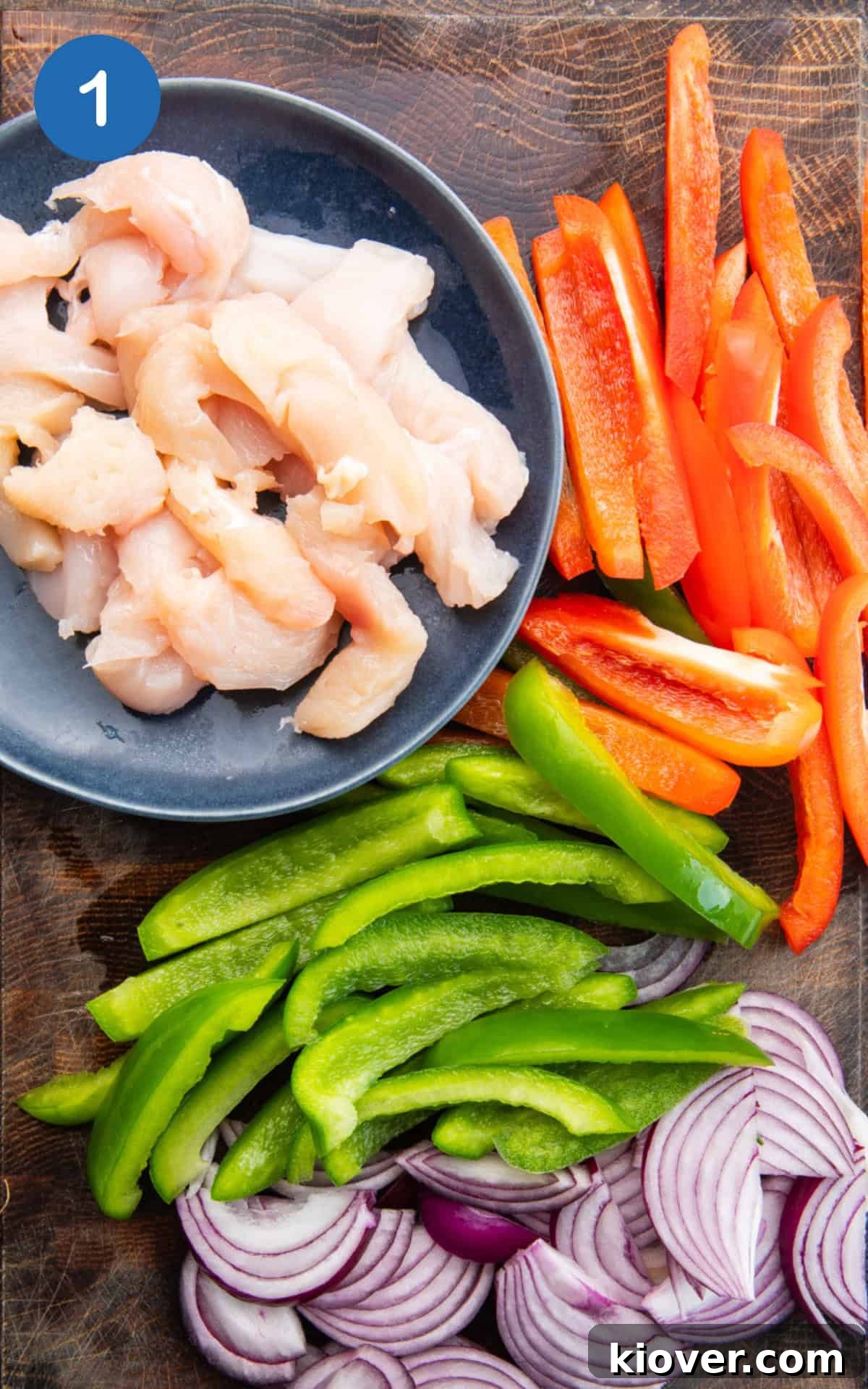 Crispy Air Fryer Chicken Fajitas Recipe for Quick Weeknight Meals 4 chicken, peppers and onion on a wooden cutting board.