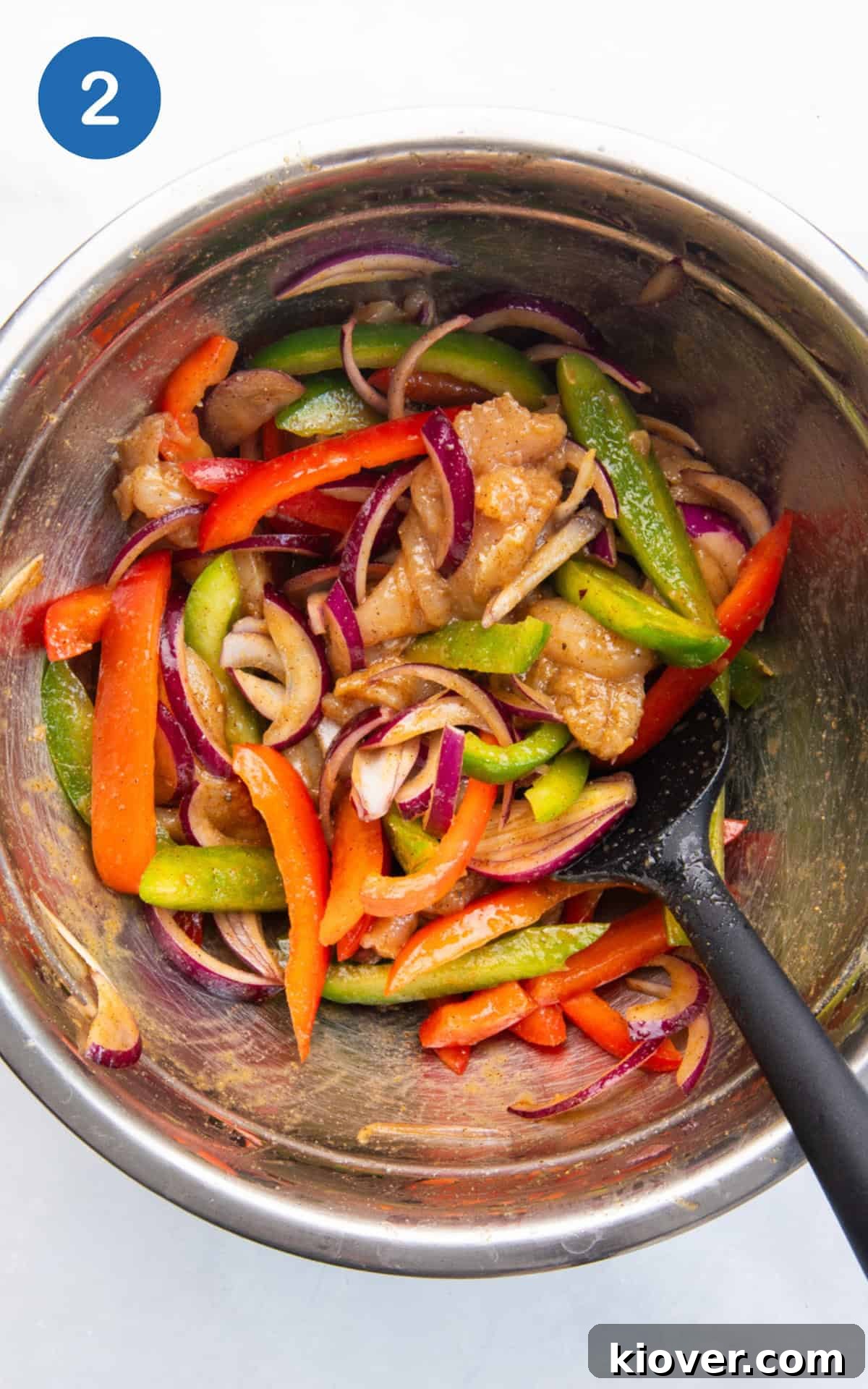 Crispy Air Fryer Chicken Fajitas Recipe for Quick Weeknight Meals 5 chicken, peppers, onion with olive oil, fajita seasoning, salt, and pepper in a bowl.
