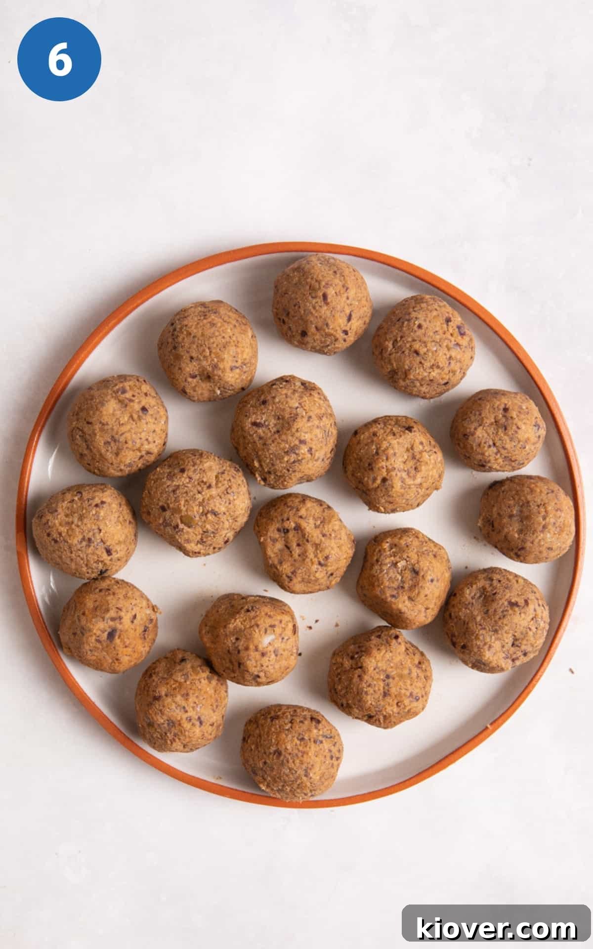 meatballs before being cooked on a white plate with orange rim.