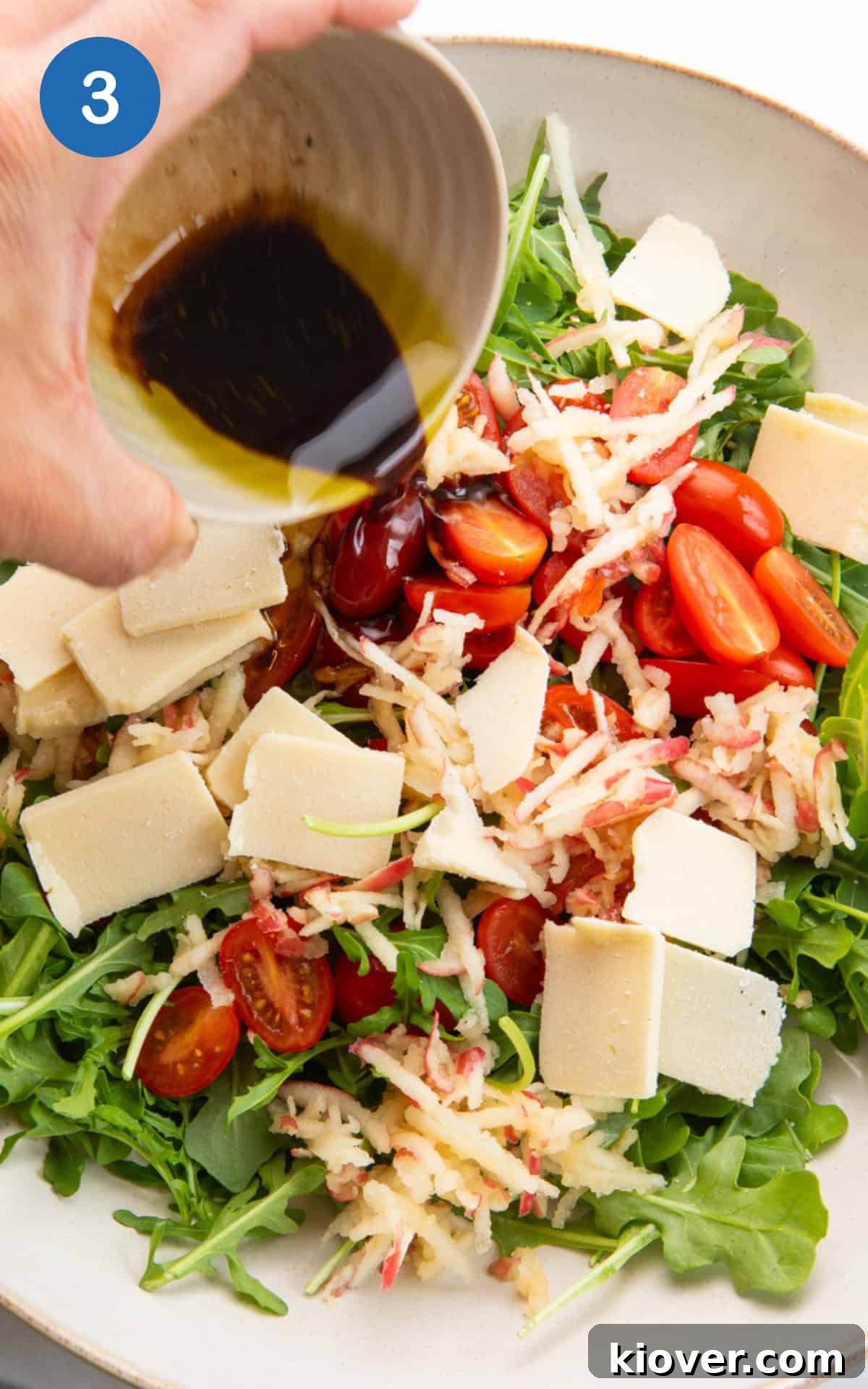 Pouring dressing on the rocket salad.