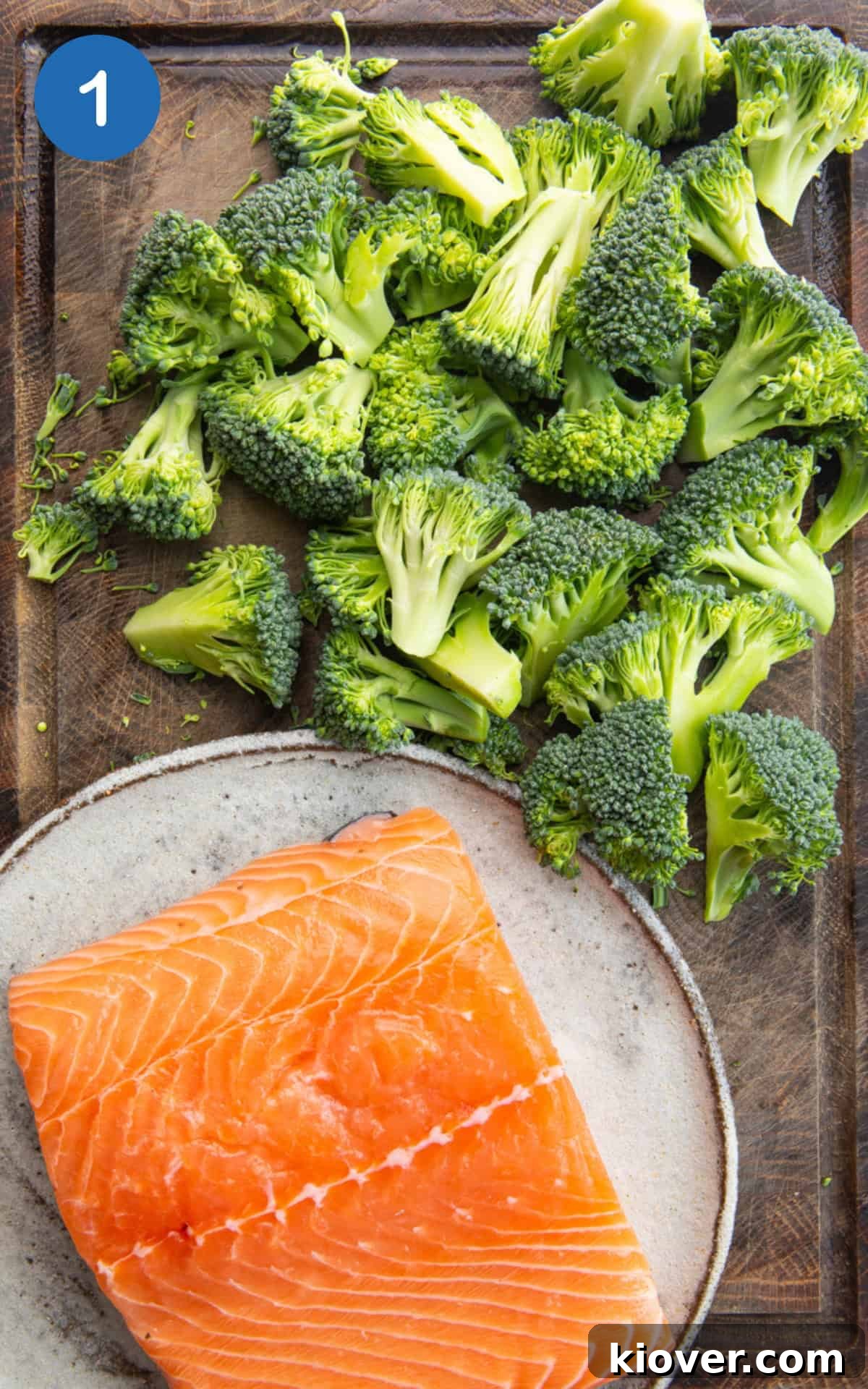 Creamy Salmon & Broccoli Pasta Recipe for Weeknight Dinners 4 skinned salmon fillet and chopped broccoli on a wooden cutting board.