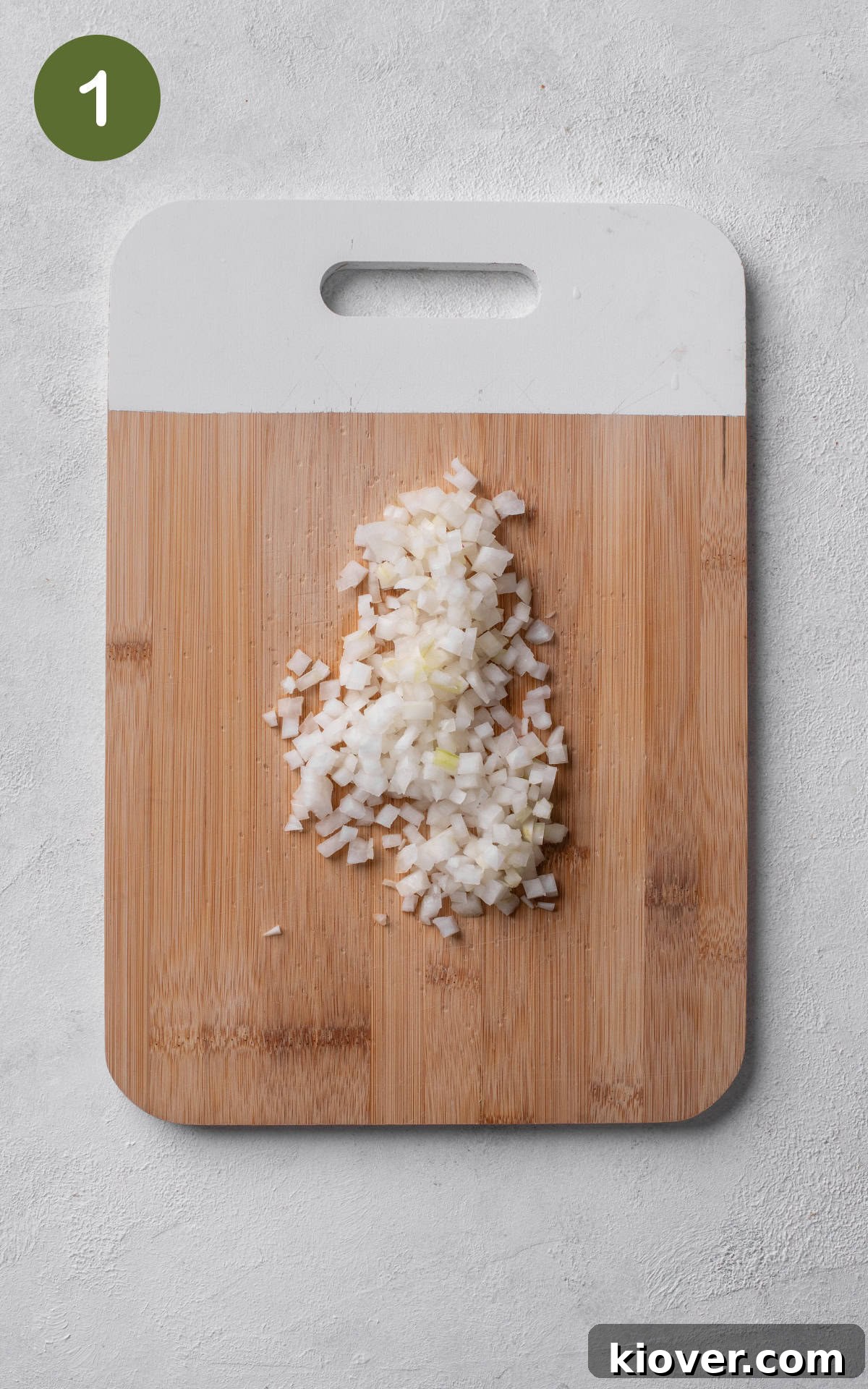 Creamy Butterbean Stew with Garlic and Herbs 4 diced onions on a wooden cutting board.