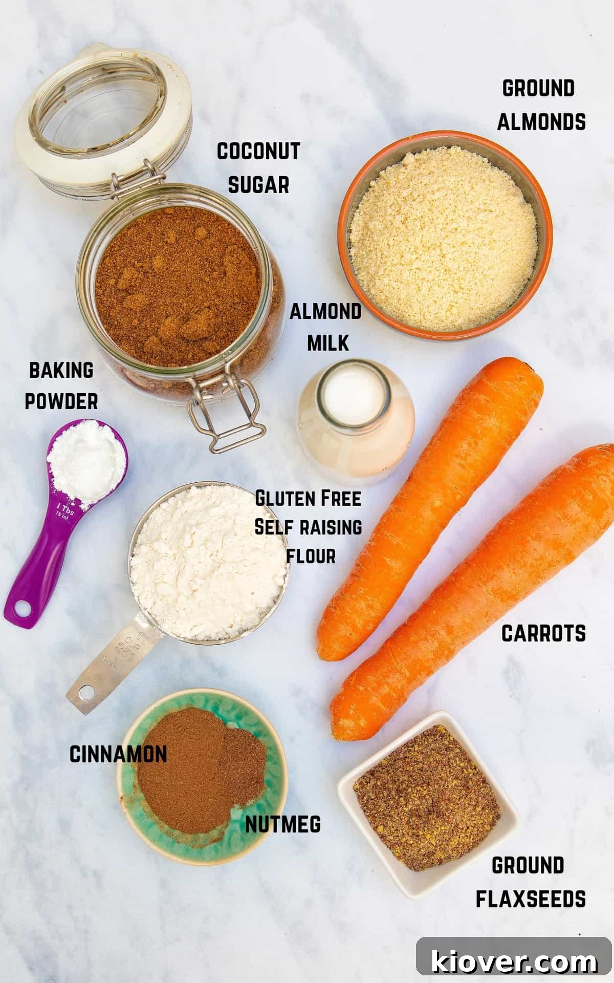 ingredients to make carrot cake on white surface.