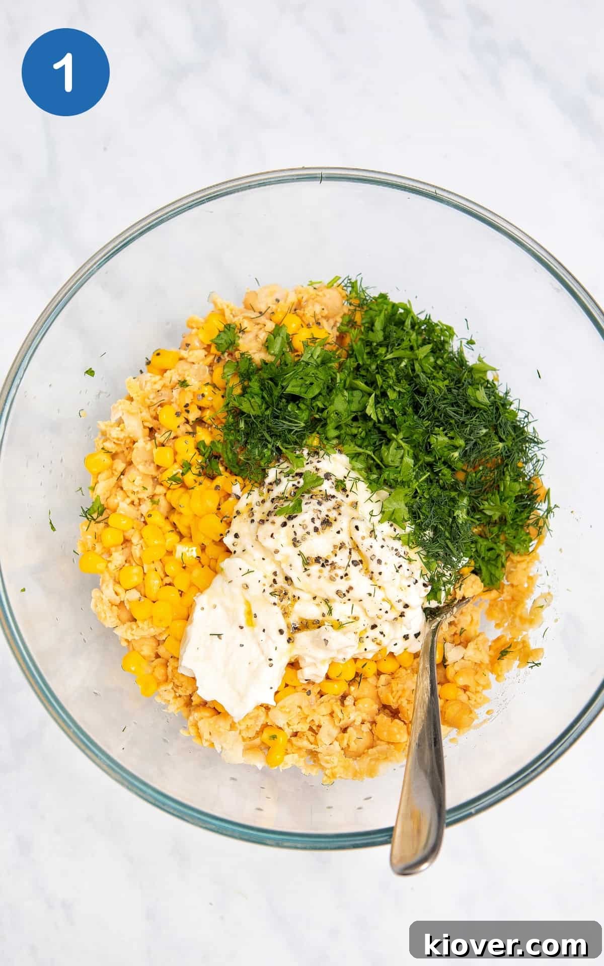 Chickpea and Tuna Salad Recipe for Meal Prep 4 prepared ingredients in a glass bowl sitting on a white surface.