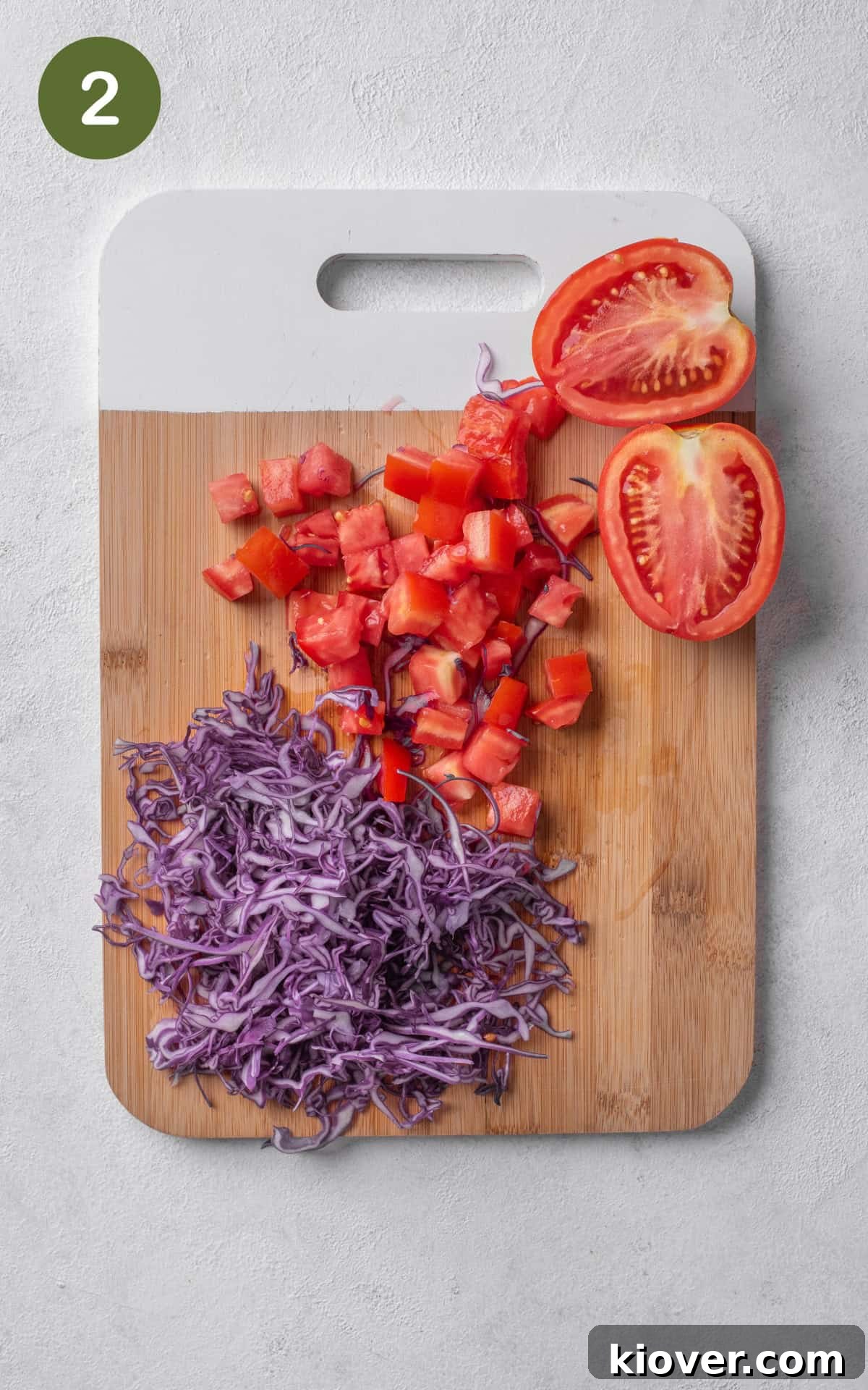 red pepper, tomatoes and cabbage on a wooden cutting board.