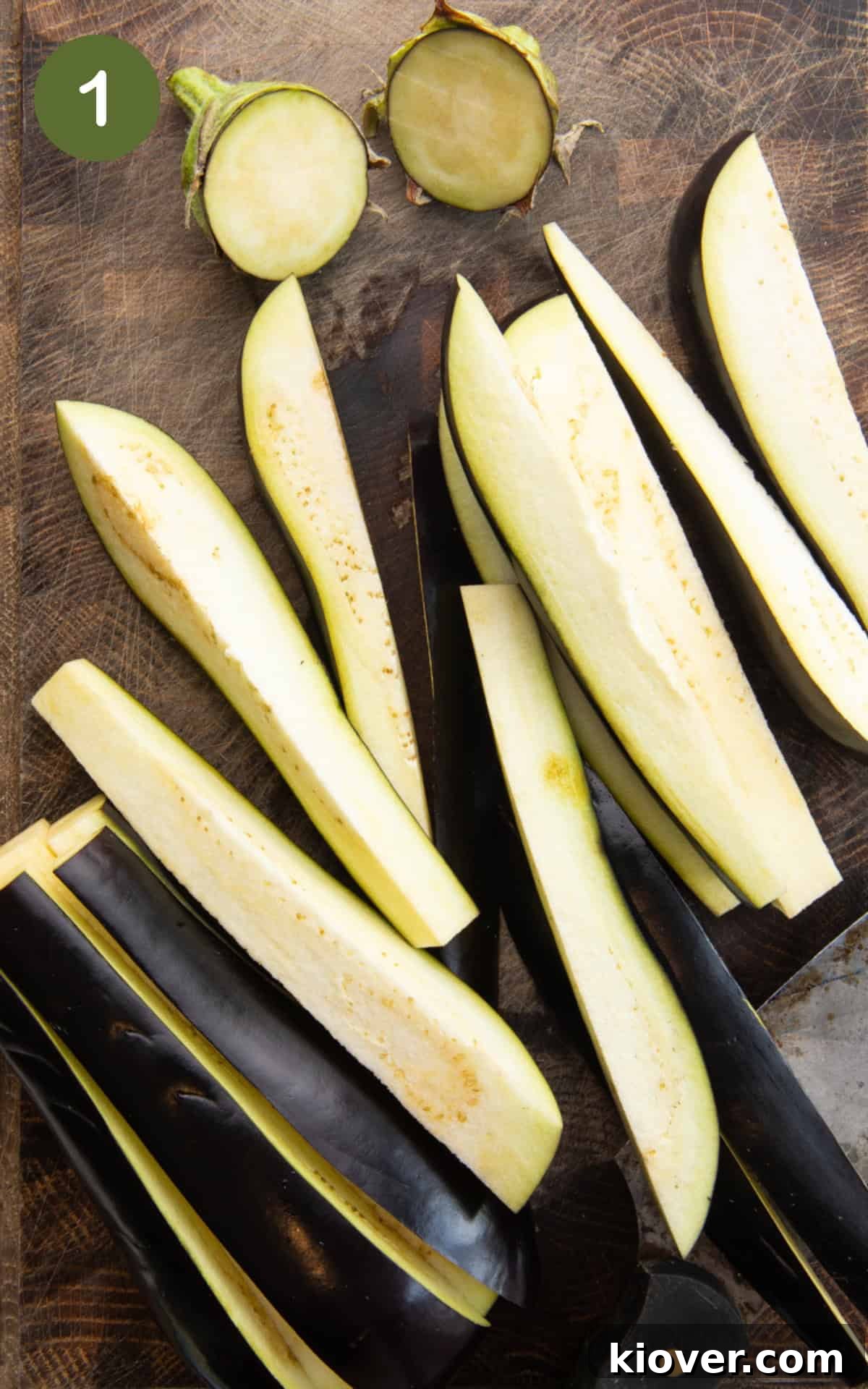 slices of aubergine on a wooden cutting board.