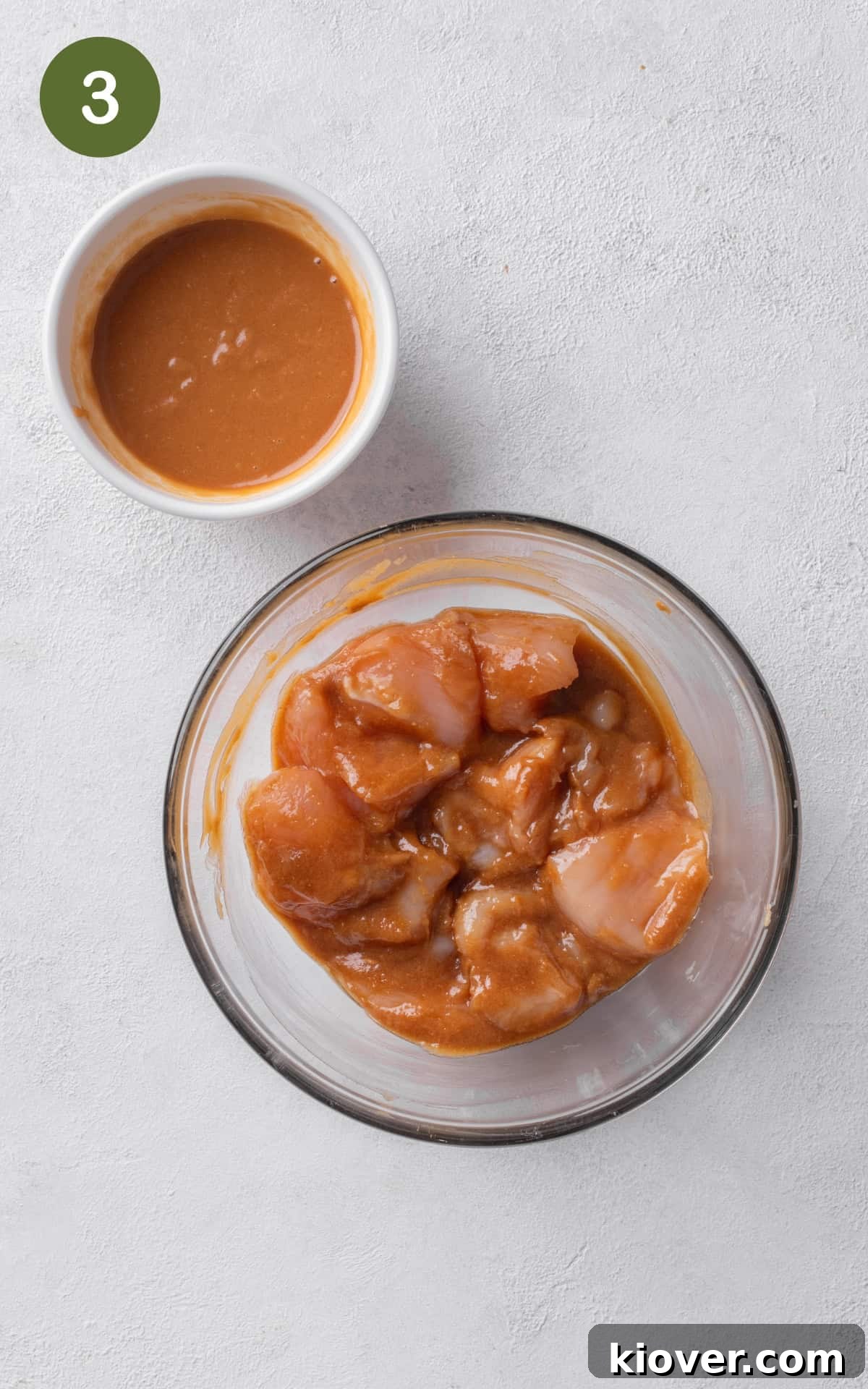 mixing chicken with the dressing in a bowl.