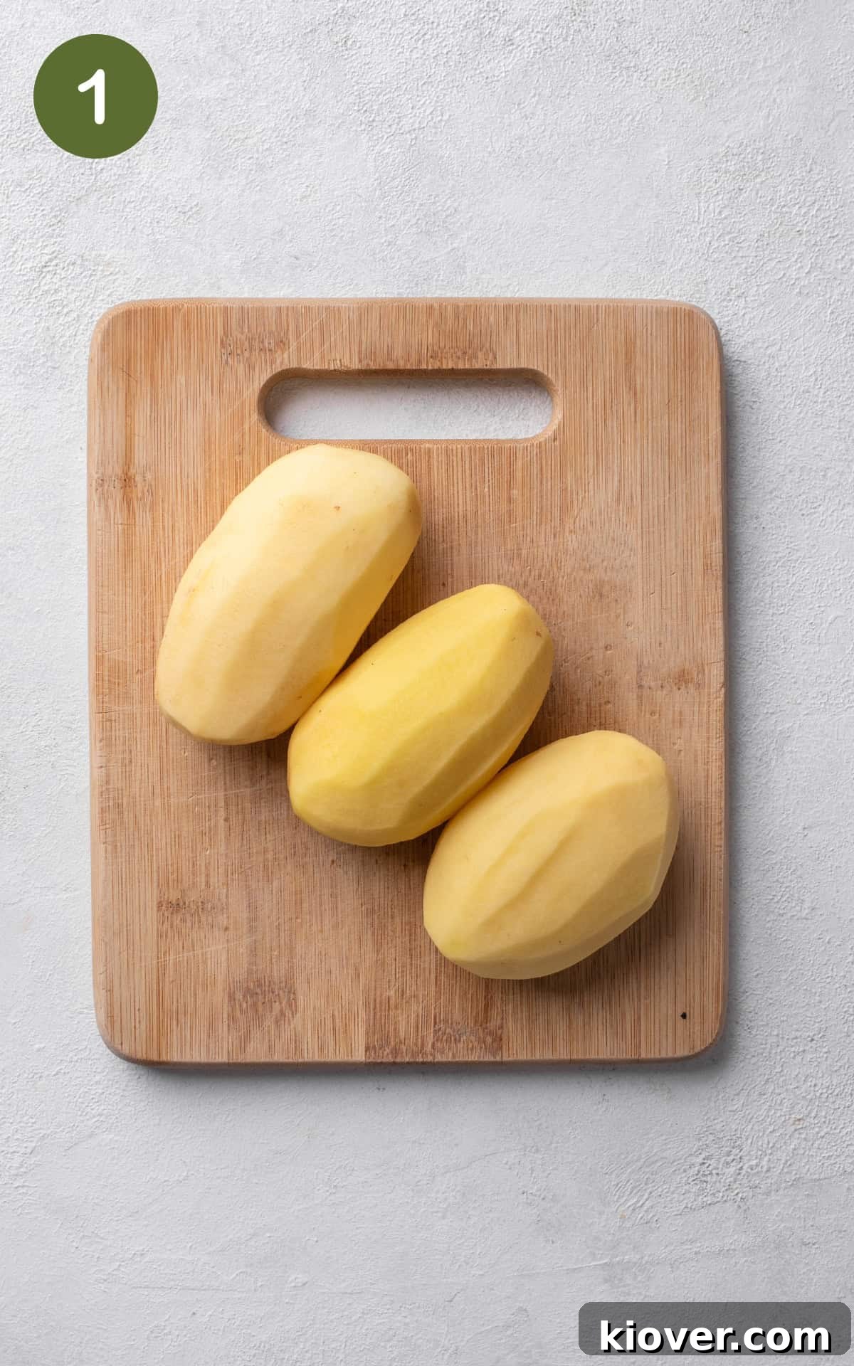 Crispy Swiss Potato Rösti Recipe — Golden Hash Brown Style 4 potatoes on a wooden cutting board.
