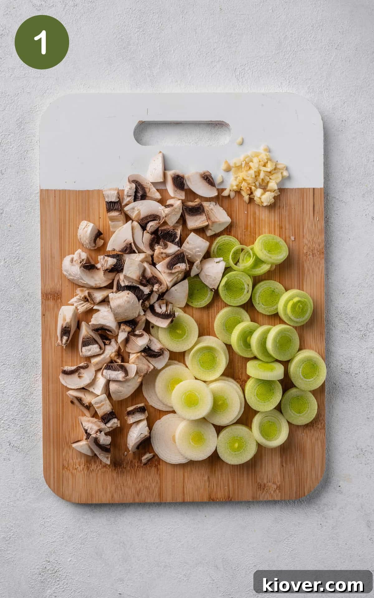 Classic Chicken and Leek Pie Recipe for Comforting Dinner 4 mushrooms, leek and garlic on a wooden cutting board.