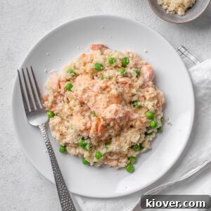 salmon risotto with peas served on a white plate.