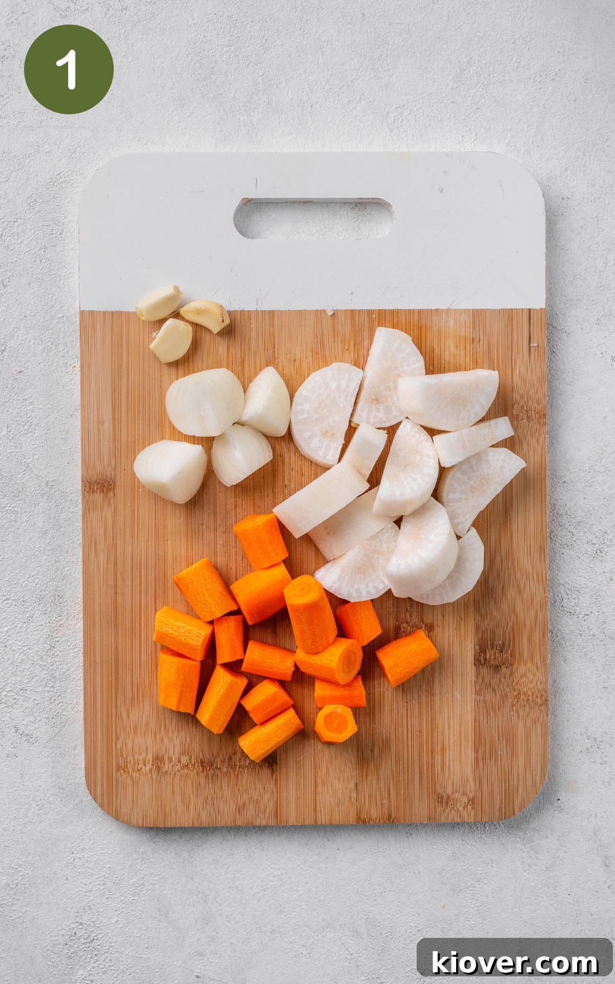 Creamy Carrot and Parsnip Soup Recipe for Cozy Weeknights 4 chopped carrots, parsnip and onions on a wooden cutting board.