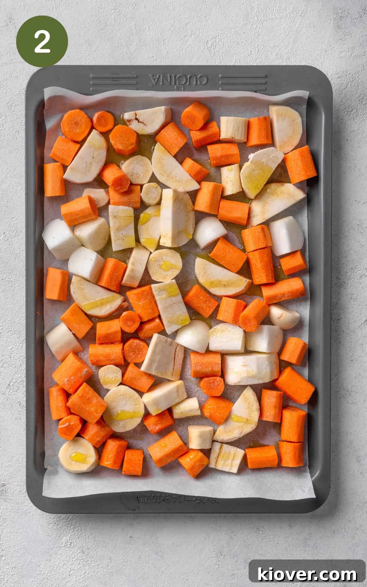 Creamy Carrot and Parsnip Soup Recipe for Cozy Weeknights 5 carrots, parsnip, and garlic on a baking tray.