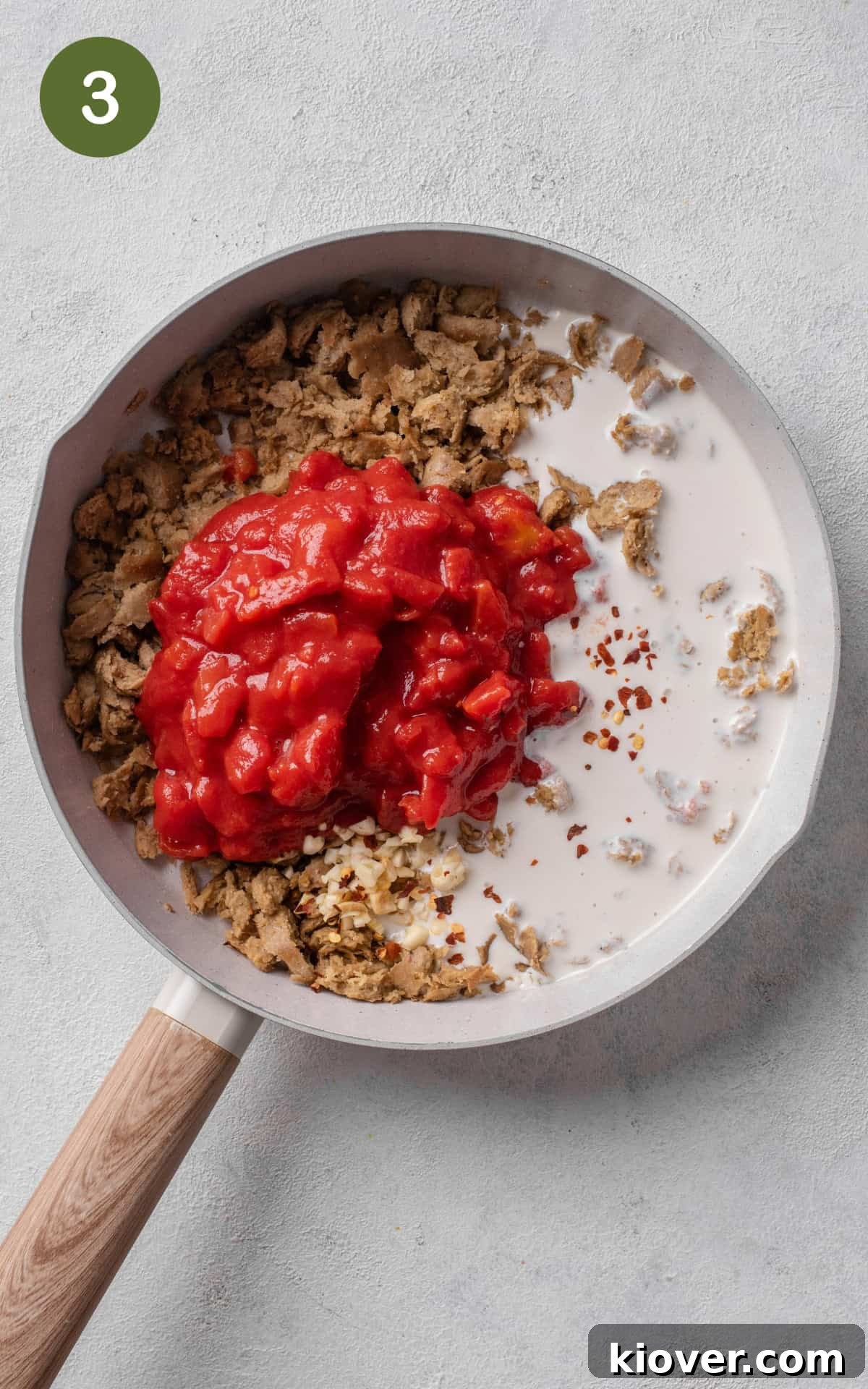 garlic, chopped tomatoes, cream, chili flakes and sausages in a skillet.