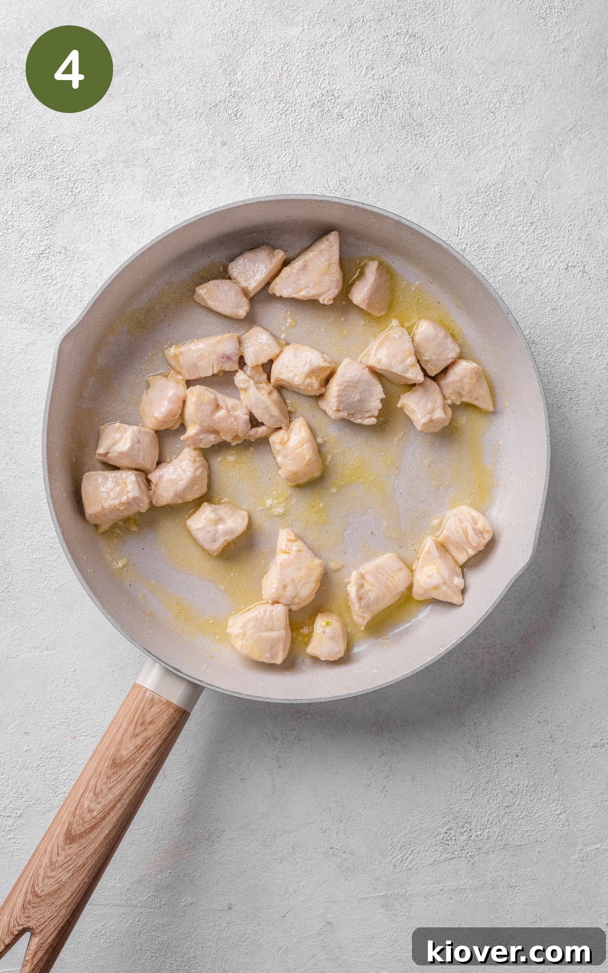Creamy Chicken Pasta Bake with Melty Cheese and Herbs 7 frying chicken on a skillet.