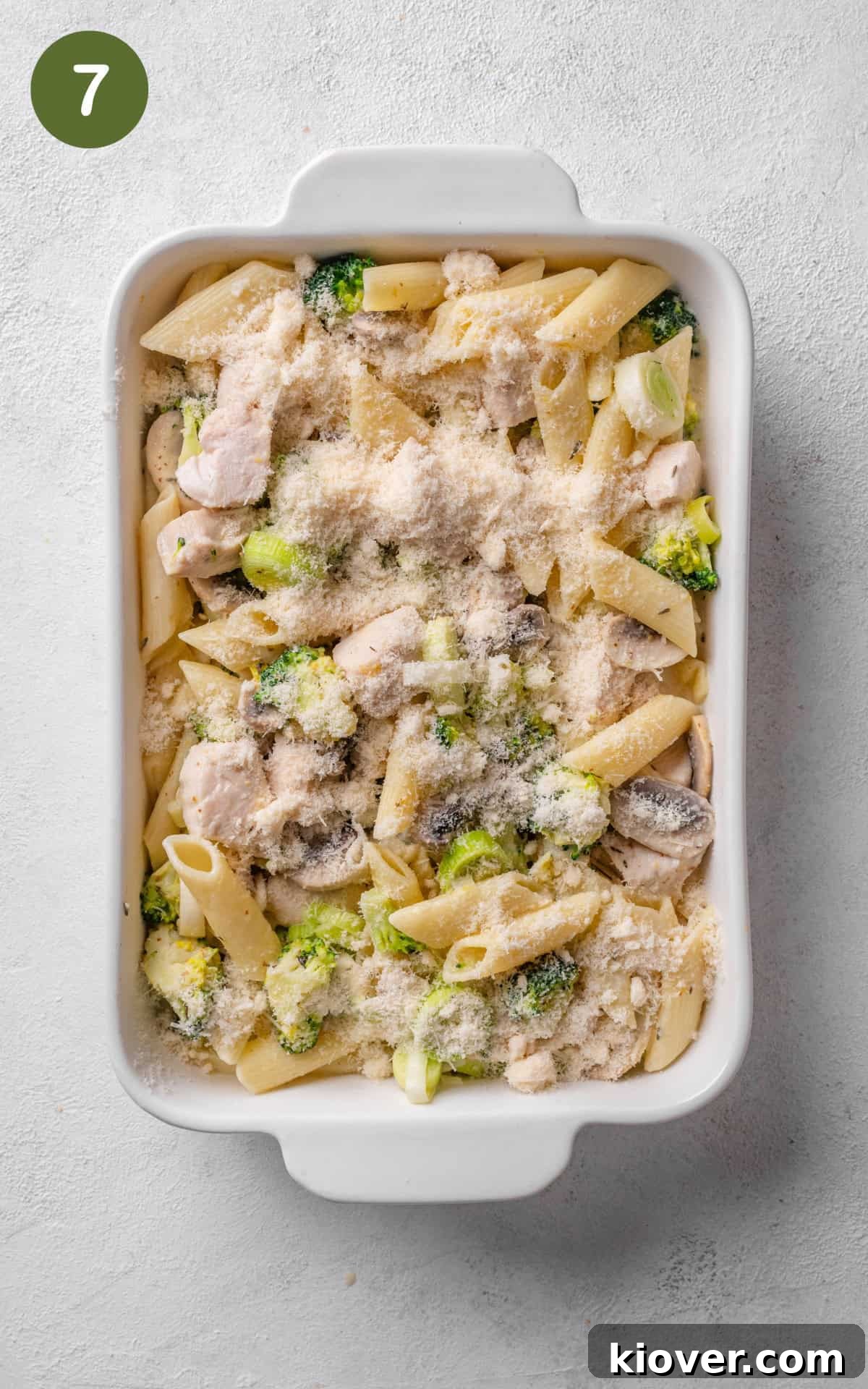 Creamy Chicken Pasta Bake with Melty Cheese and Herbs 10 pasta in a baking dish with cheese on top.