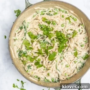 spaghetti carbonara in large frying pan topped with freshly chopped parsley