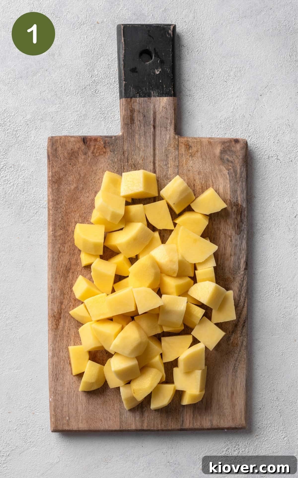 Crispy Potato Waffles Recipe: Homemade Hash Brown Waffles 4 potatoes cut into cubes on a wooden cutting board.
