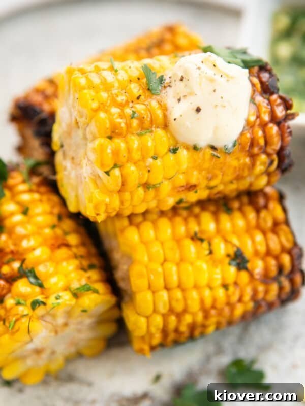 Air fryer corn on the cob served with cream on top.