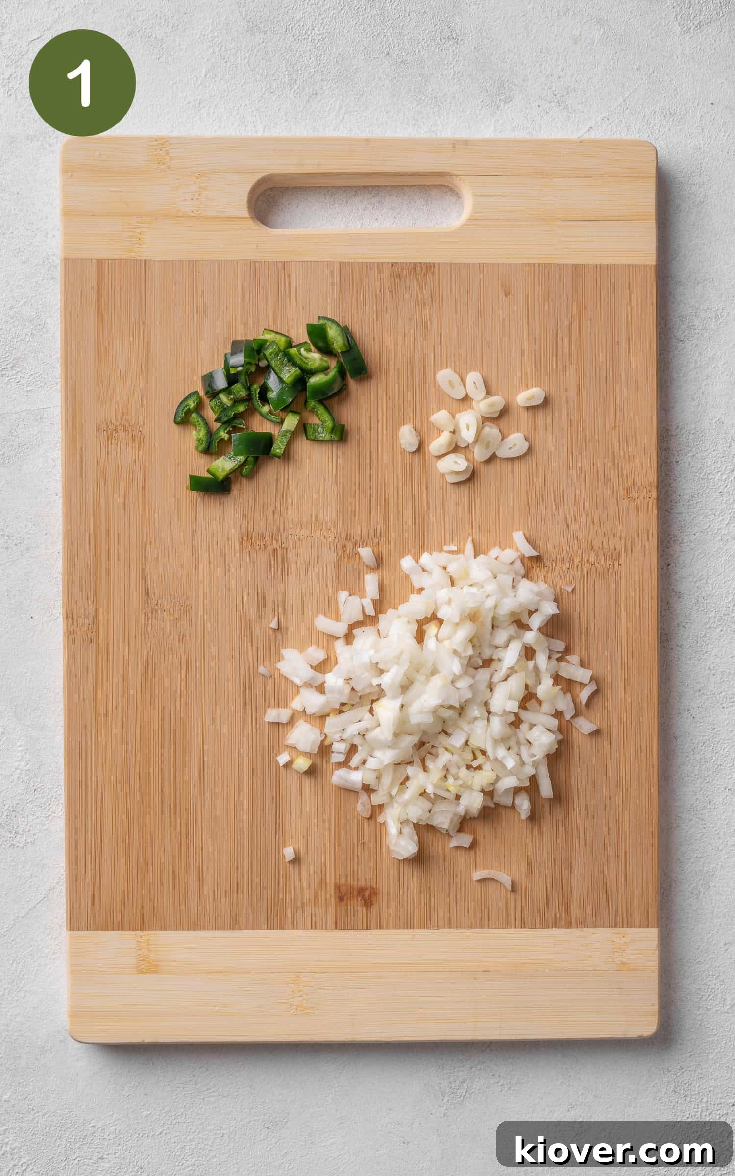 Authentic Mexican Soup Recipe: Flavorful Caldo de Res Guide 4 jalapenos, onions and garlic on a wooden cutting board.