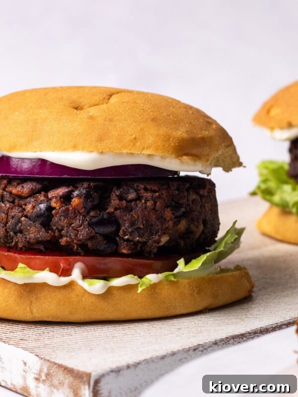 mushroom burgers in a bun with potato wedges on the side.
