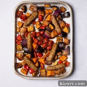 Sausage Tray Bake Recipe with Roasted Veggies and Herb Gravy 12 Sausages baked on the tray with colourful vegetables.