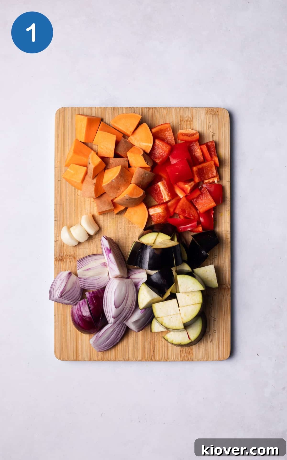Sausage Tray Bake Recipe with Roasted Veggies and Herb Gravy 4 Chopped vegetables on a wooden cutting board.