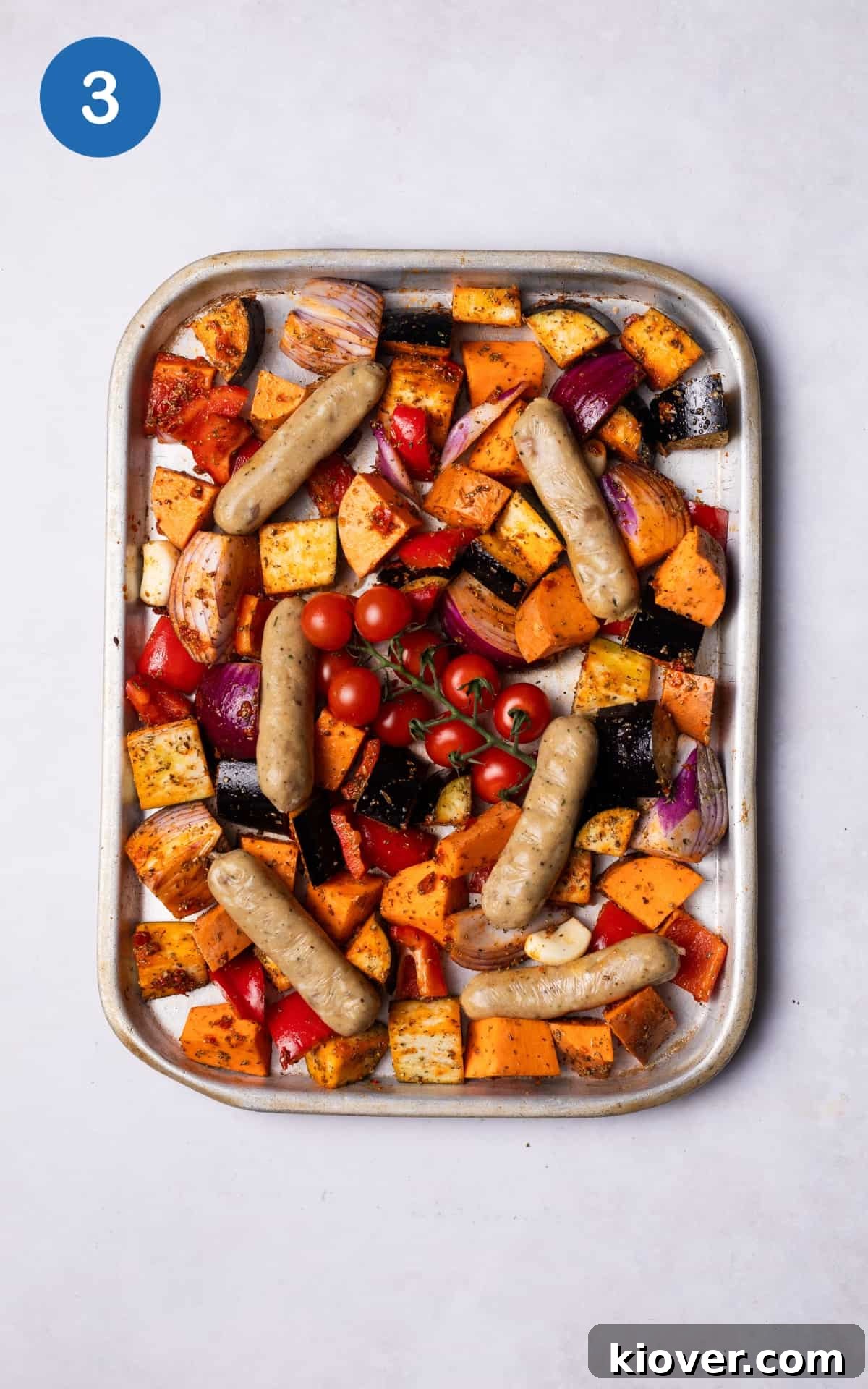 Sausage Tray Bake Recipe with Roasted Veggies and Herb Gravy 6 Sausages added to the tray with the vegetables.
