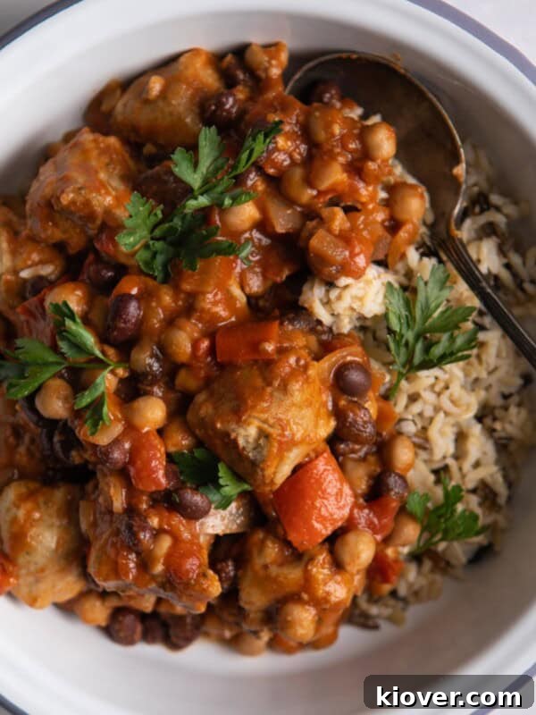 Sausage Tray Bake Recipe with Roasted Veggies and Herb Gravy 8 close overhead shot of Slow Cooker Sausage Casserole with brown rice in a white bowl.