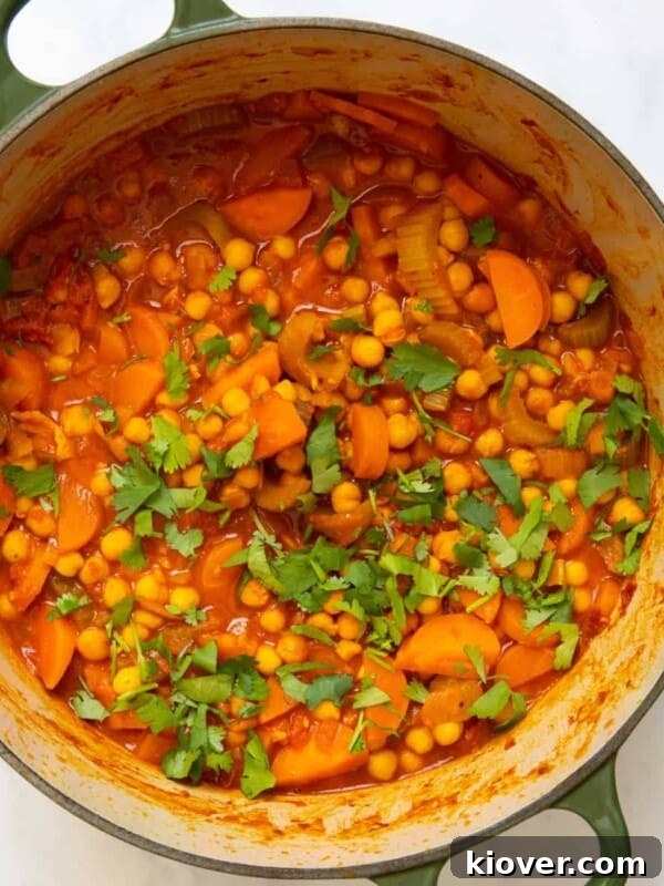 Chickpea stew in a large pot displayed on white bakcground.
