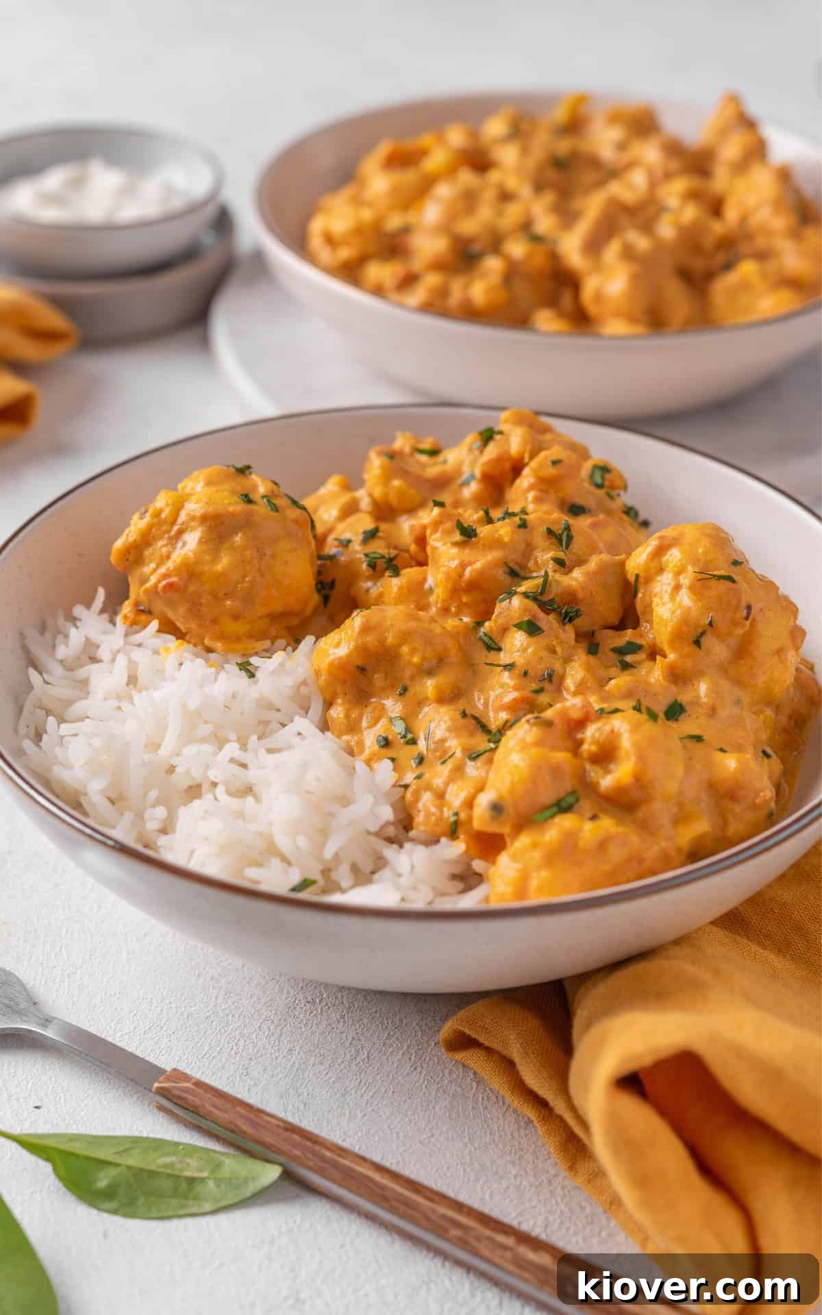 cauliflower curry served with white rice in a white bowl.