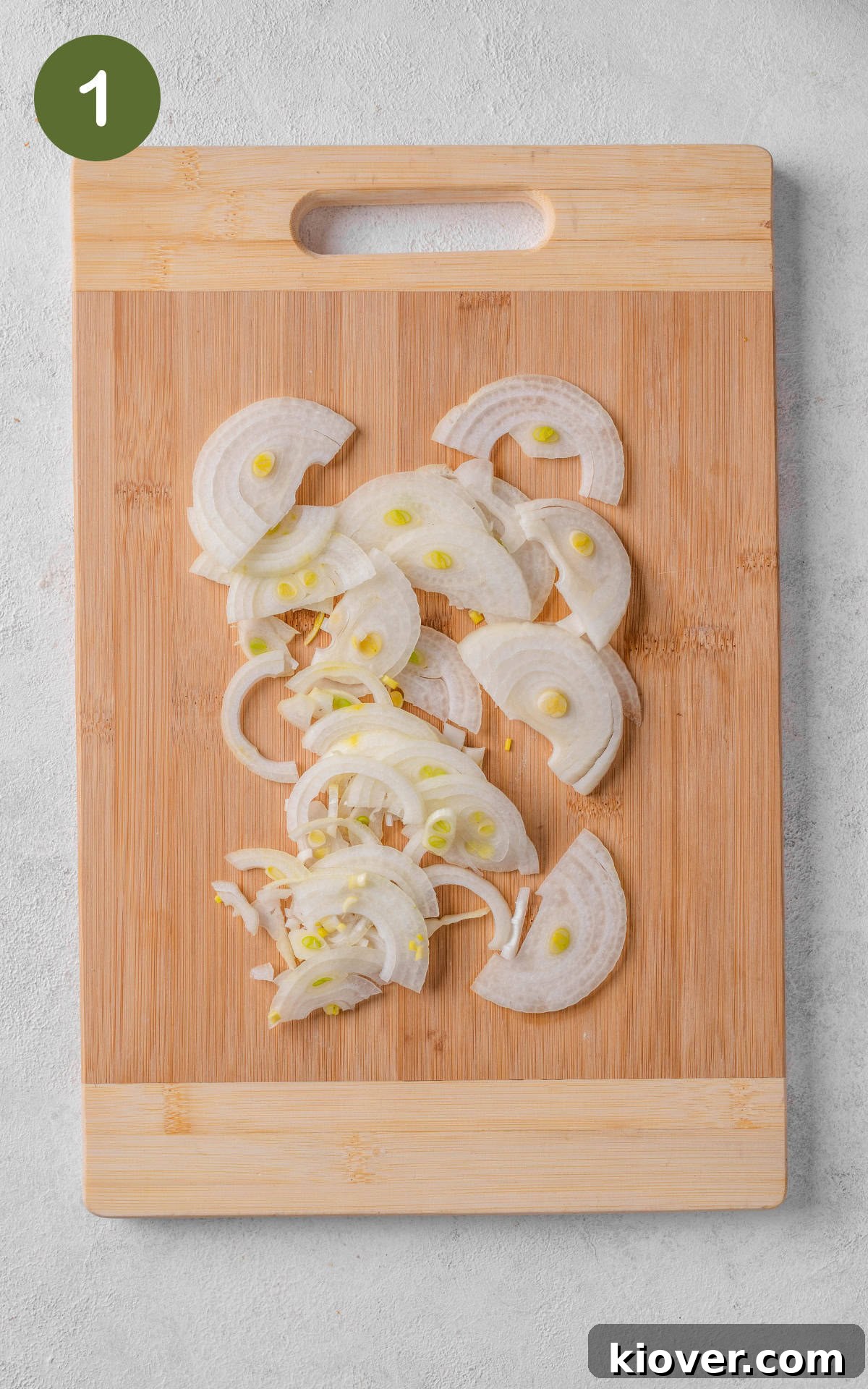 Classic Boulangère Potatoes Recipe: Crispy Potato and Onion Bake 4 sliced onions on a cutting board.