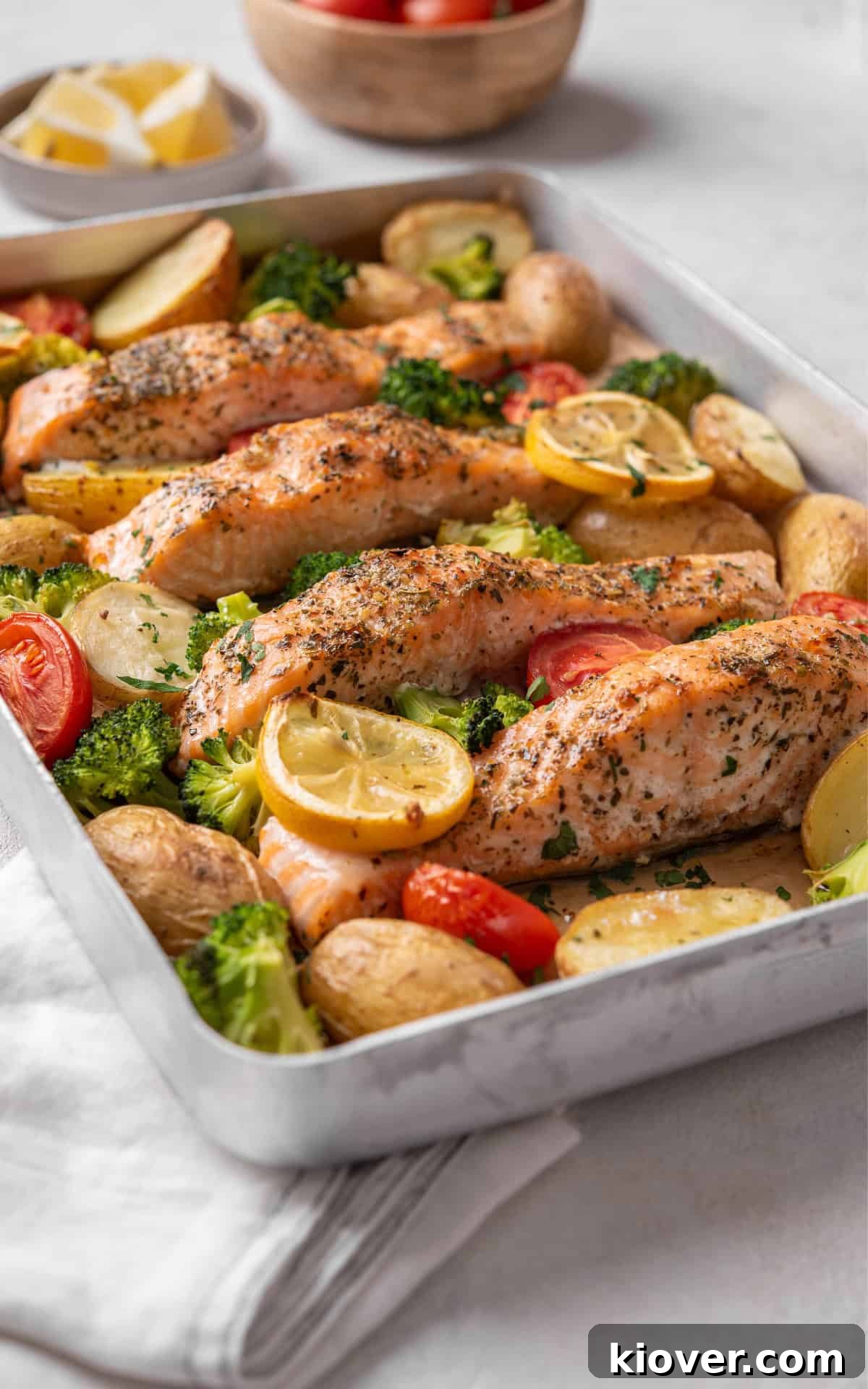 Flavorful Salmon Tray Bake with Lemon, Garlic, and Roasted Veggies 8 salmon tray bake with cherry tomatoes, potatoes and broccoli.