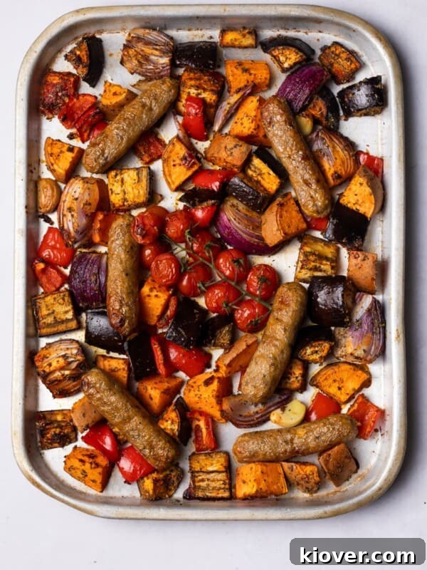 Flavorful Salmon Tray Bake with Lemon, Garlic, and Roasted Veggies 9 Sausages baked on the tray with colourful vegetables.