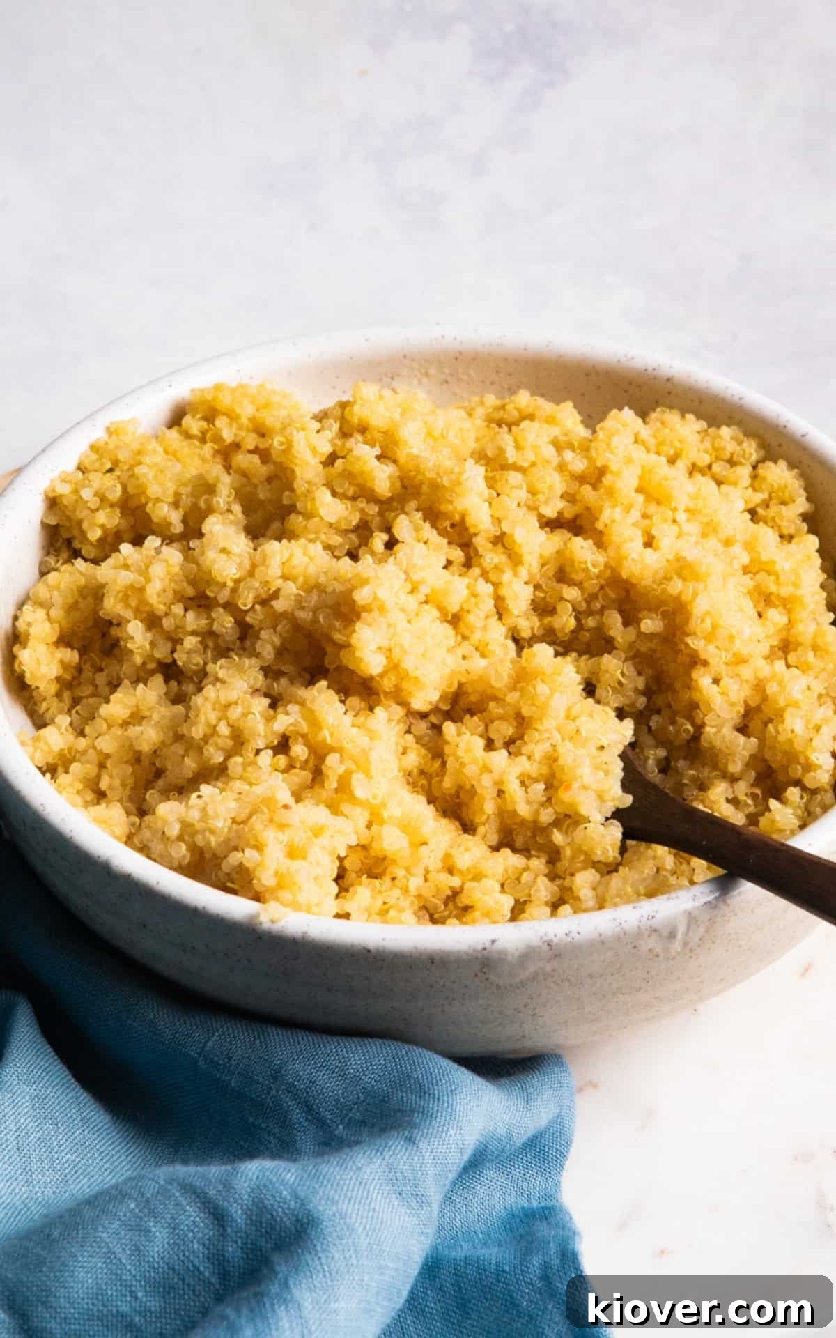 quinoa with a spoon in a white bowl on the table.