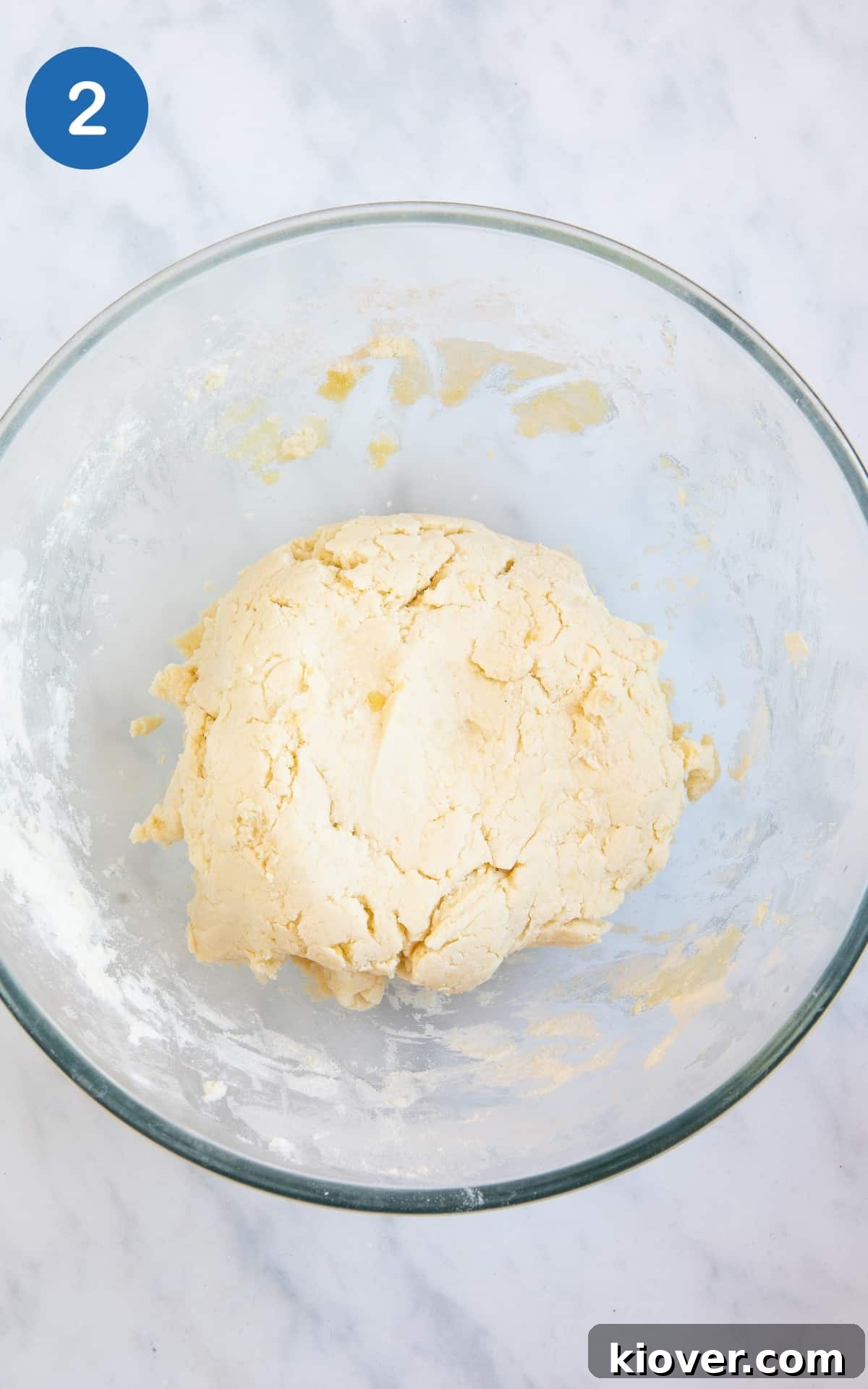 focaccia dough in transparent mixing bowl on white surface