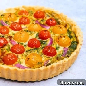 vegan quiche with a crispy pastry served on a marble worktop.