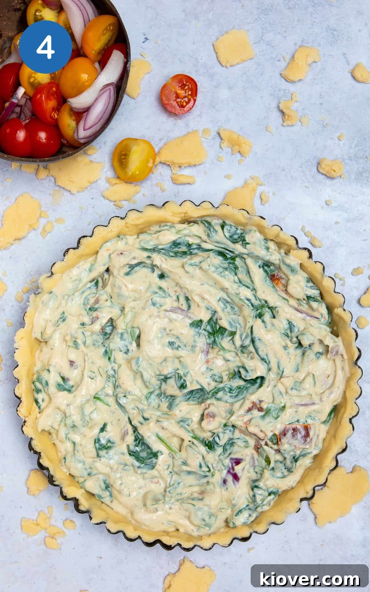 quiche on grey marble surface with filling (before being cooked).
