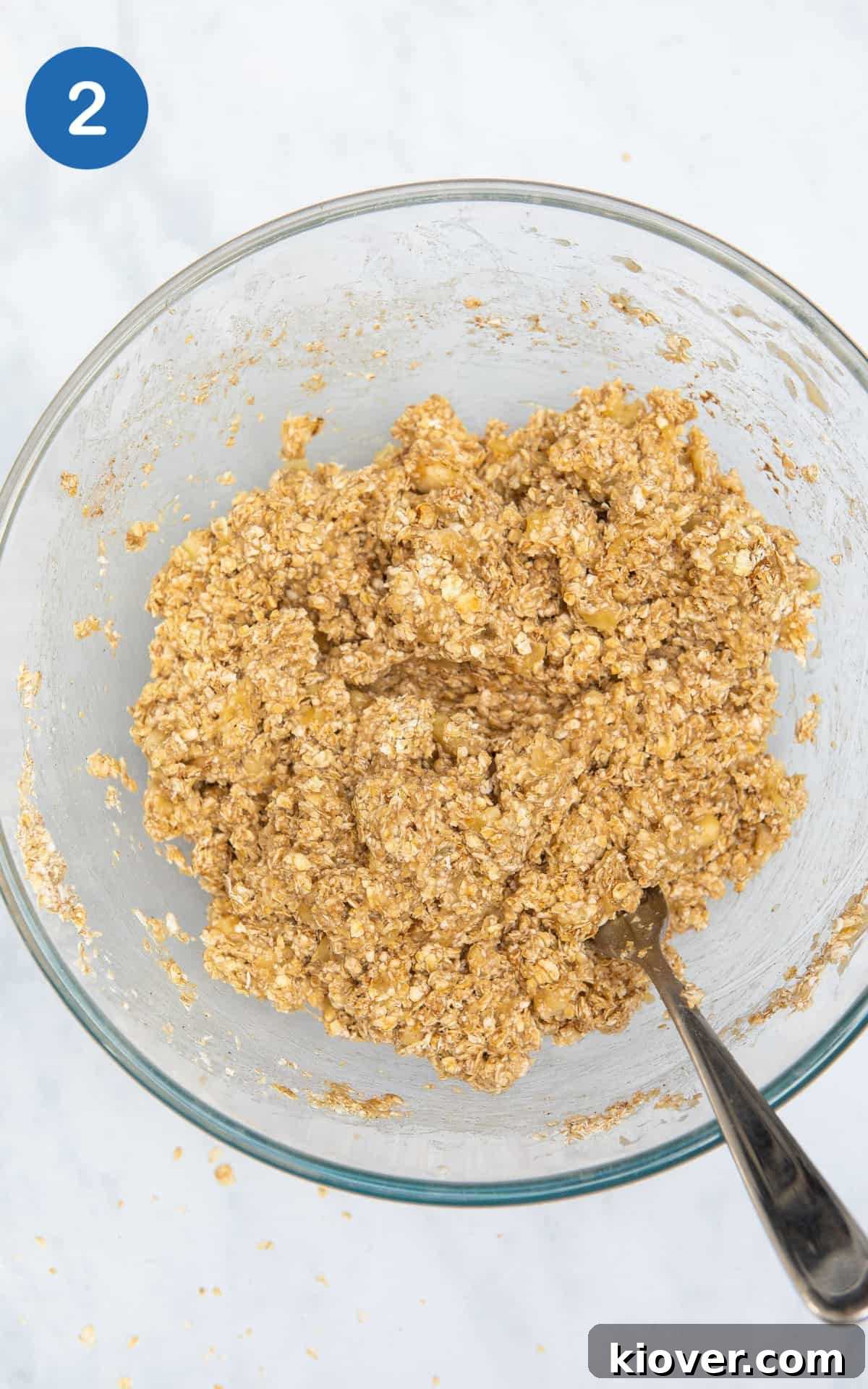 Banana Breakfast Bars with Oats and Nuts receita 5 oats, banana and cinnamon mixed together in a glass bowl.