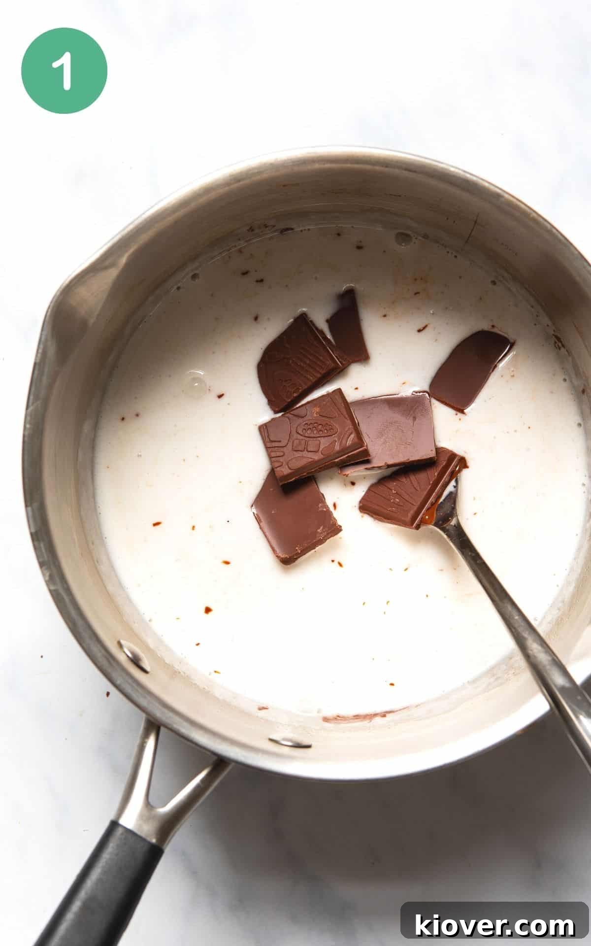Instructional photo showing chocolate being melted with coconut milk in a silver cooking pot.