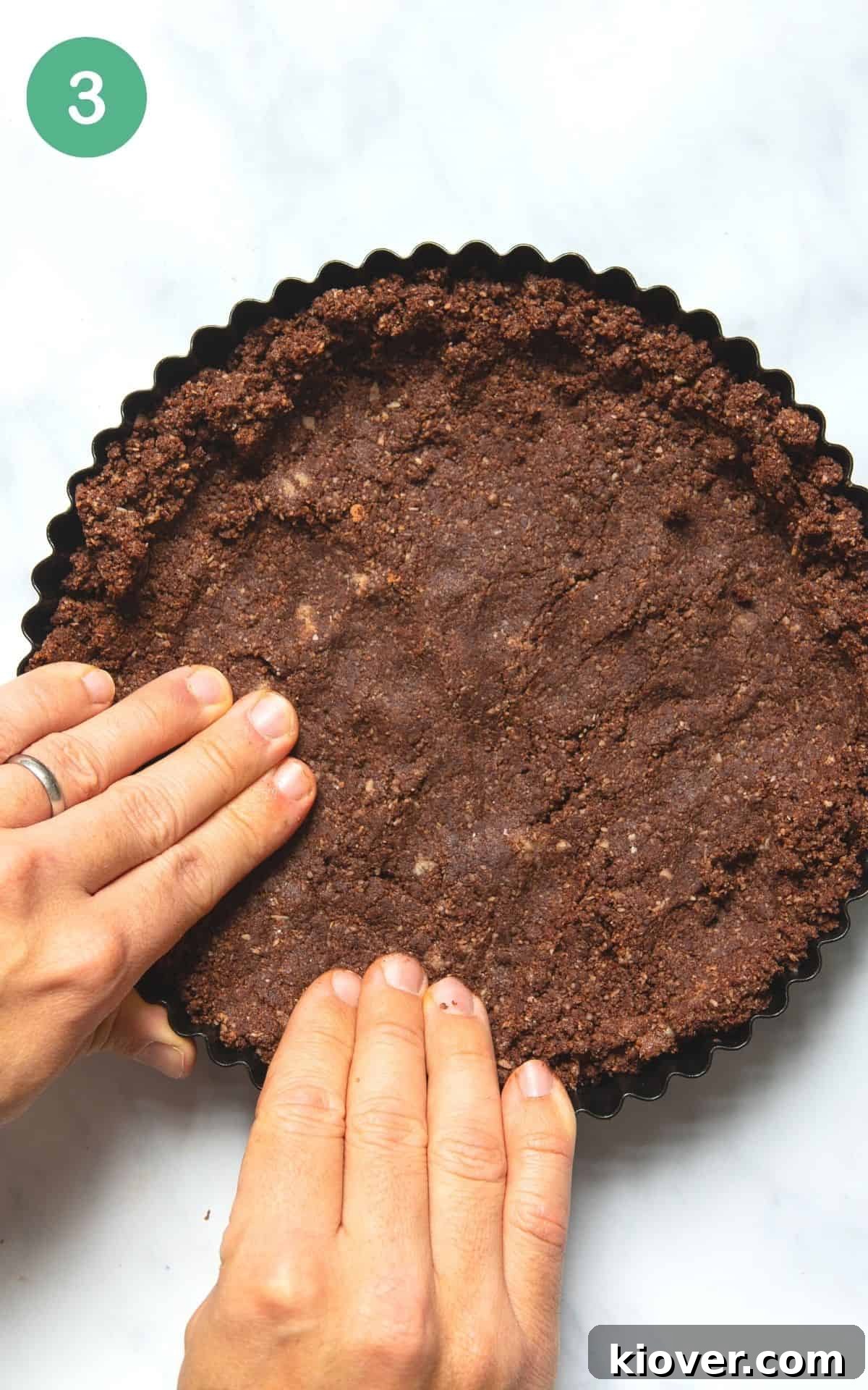 Instructional photo showing the tart crust being pressed into a tart tin.