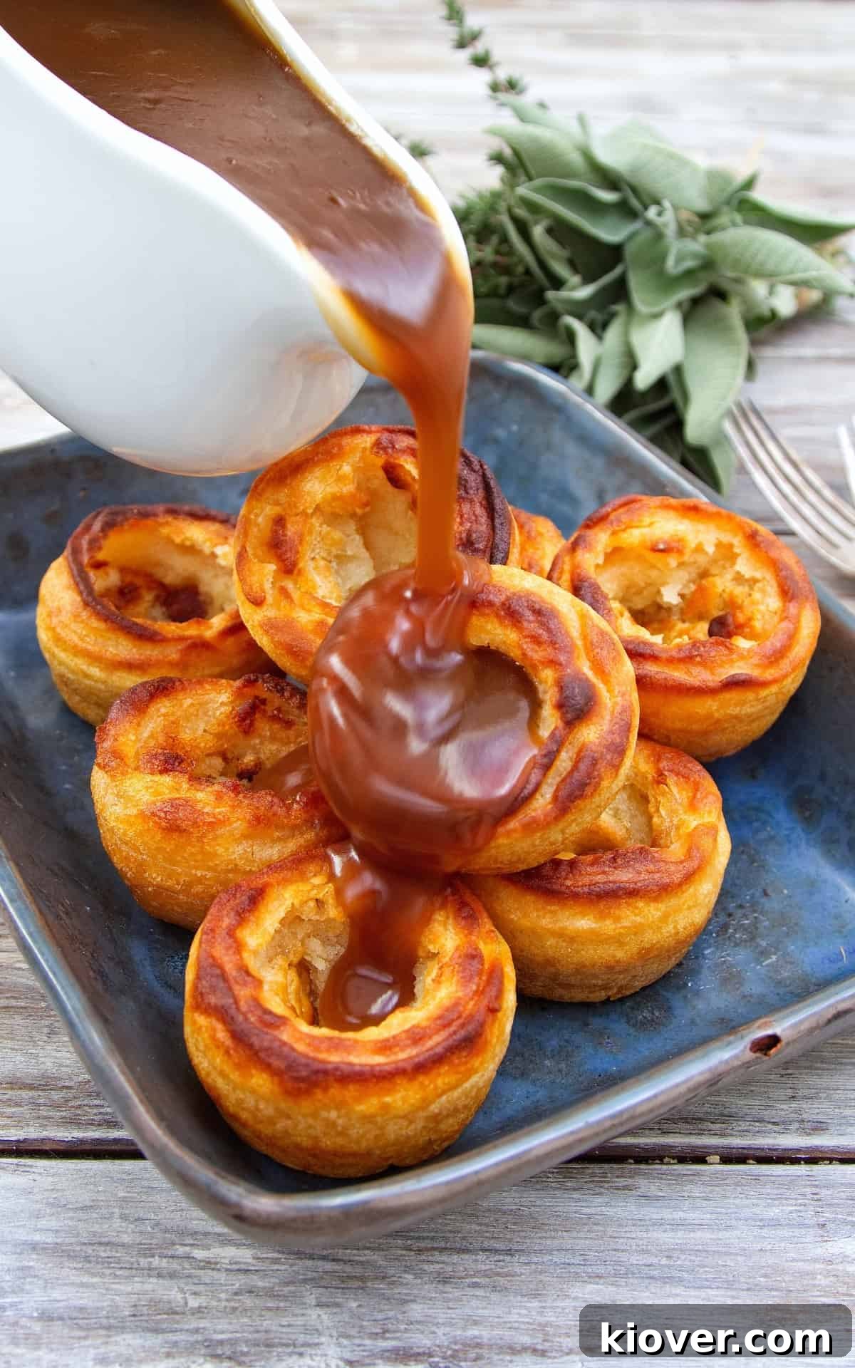 Gluten-Free Vegan Yorkshire Puddings Recipe 8 Gravy being poured over a tower of Yorkshire puddings.