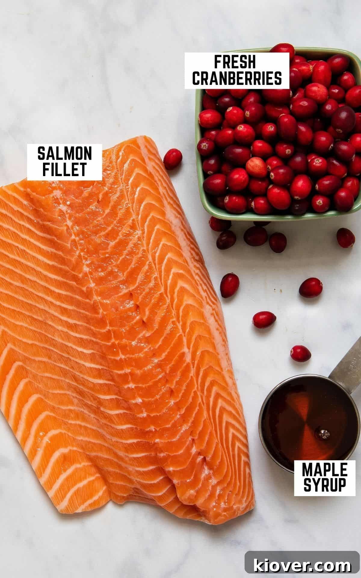 Festive Baked Salmon for Christmas Dinner 3 Overhead image of ingredients for the recipe: salmon, cranberries, and maple syrup.