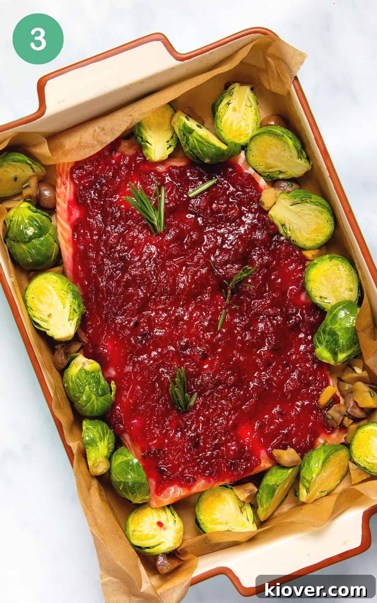 Festive Baked Salmon for Christmas Dinner 6 Placing the prepared salmon fillet with cranberry sauce on top into a baking dish.