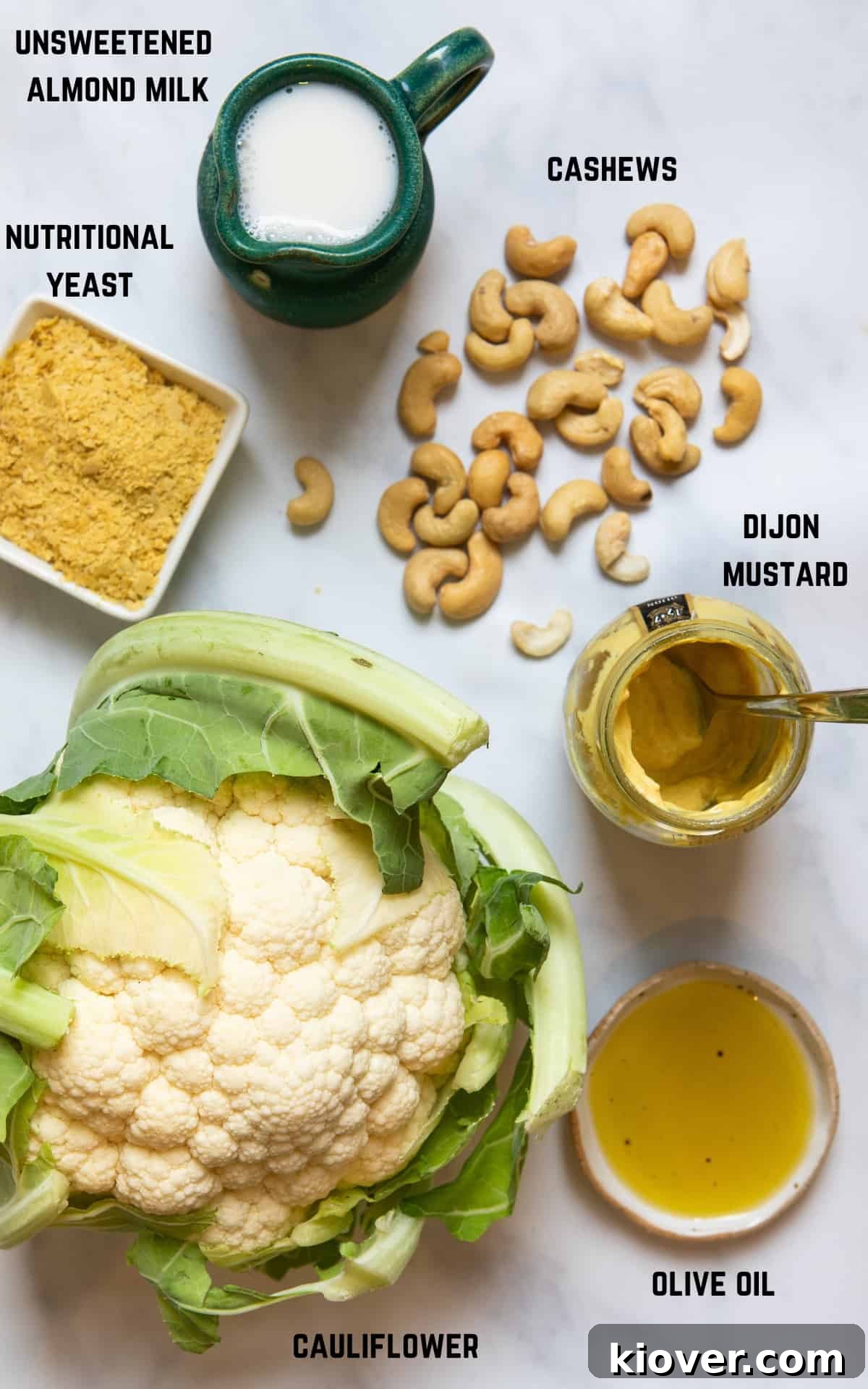 ingredients to make cauliflower cheese laid out on a white marble backdrop