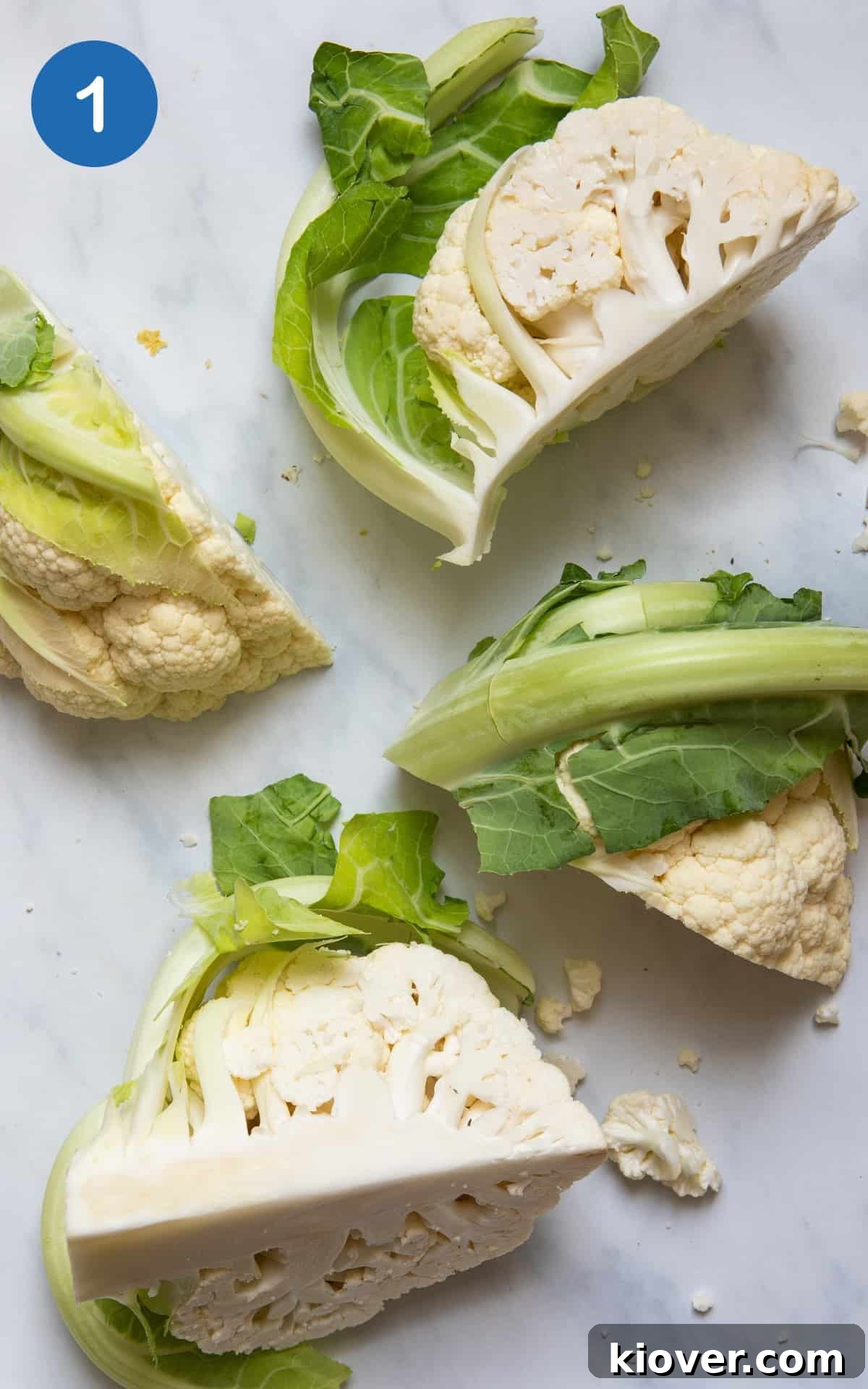 Cauliflower cut into 4 quarters on white background. 